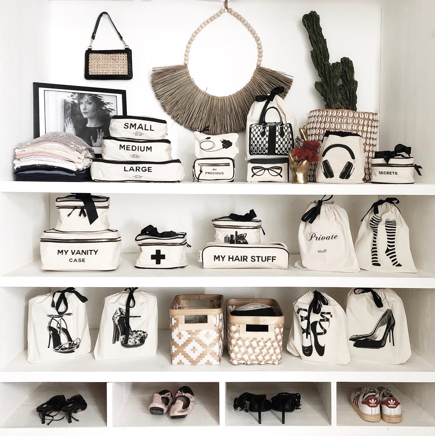 Shelf in a home organized with decor, camera case, earbuds case, books and tech cases.