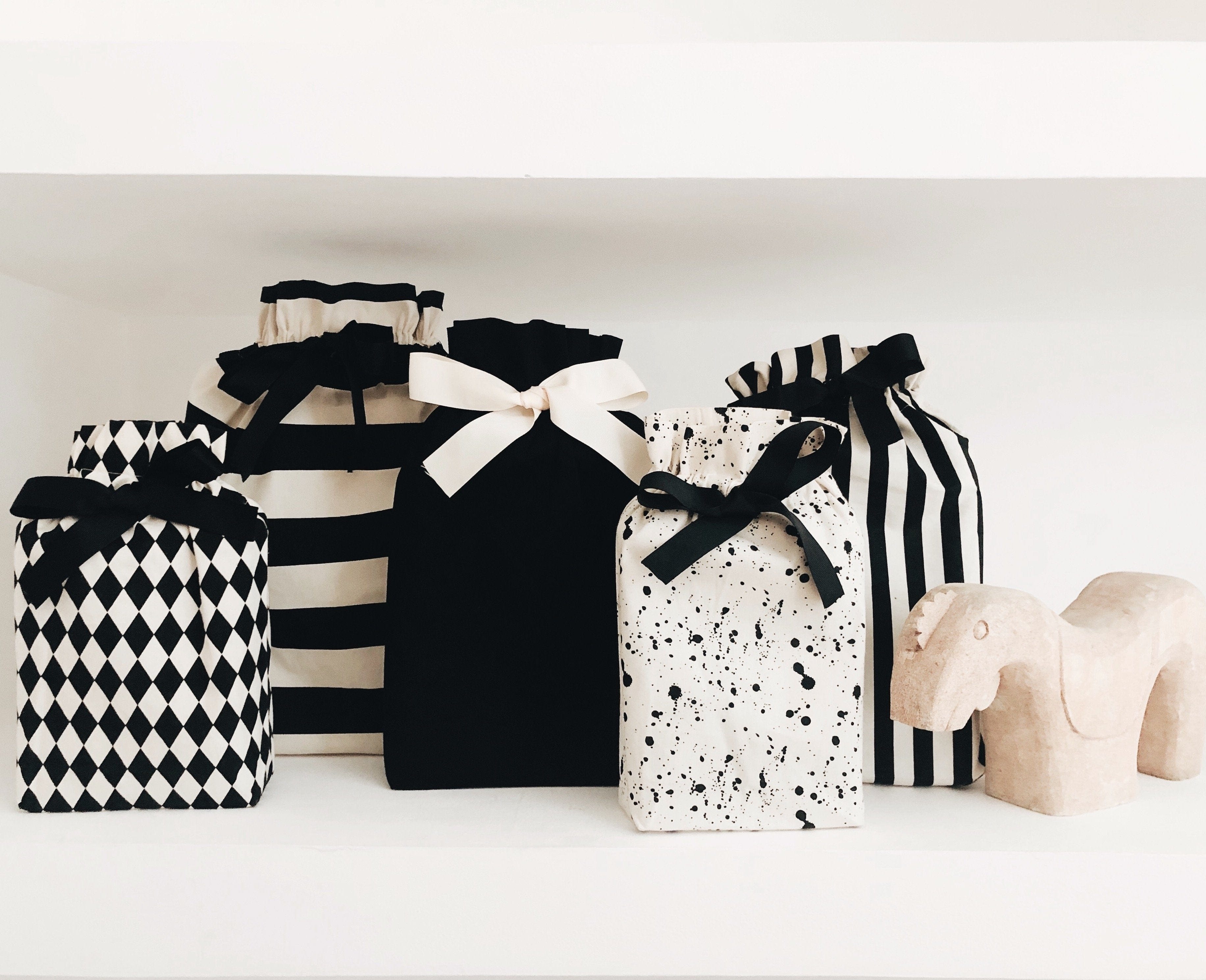 Bag-all Gift Bag Striped Large collection featuring black and white patterns - diamond print, stripes, solid, splatter design - adorned with elegant ribbon bows, perfect for sustainable gift wrapping