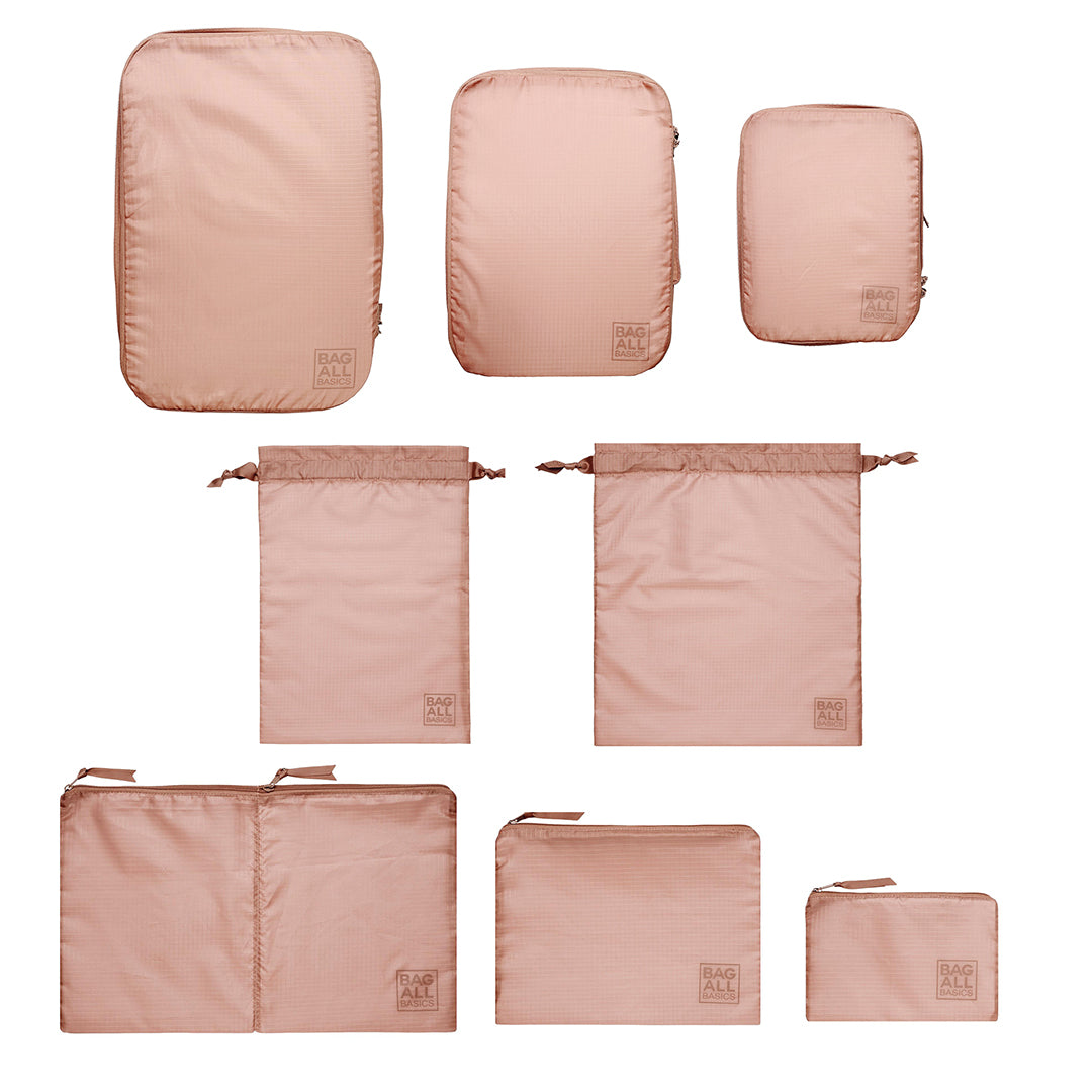 Bag-all Compression Cubes & Packing Bags Set in pink/blush features 8 sustainable travel organizers made from recycled nylon, including compression cubes and multipurpose storage bags