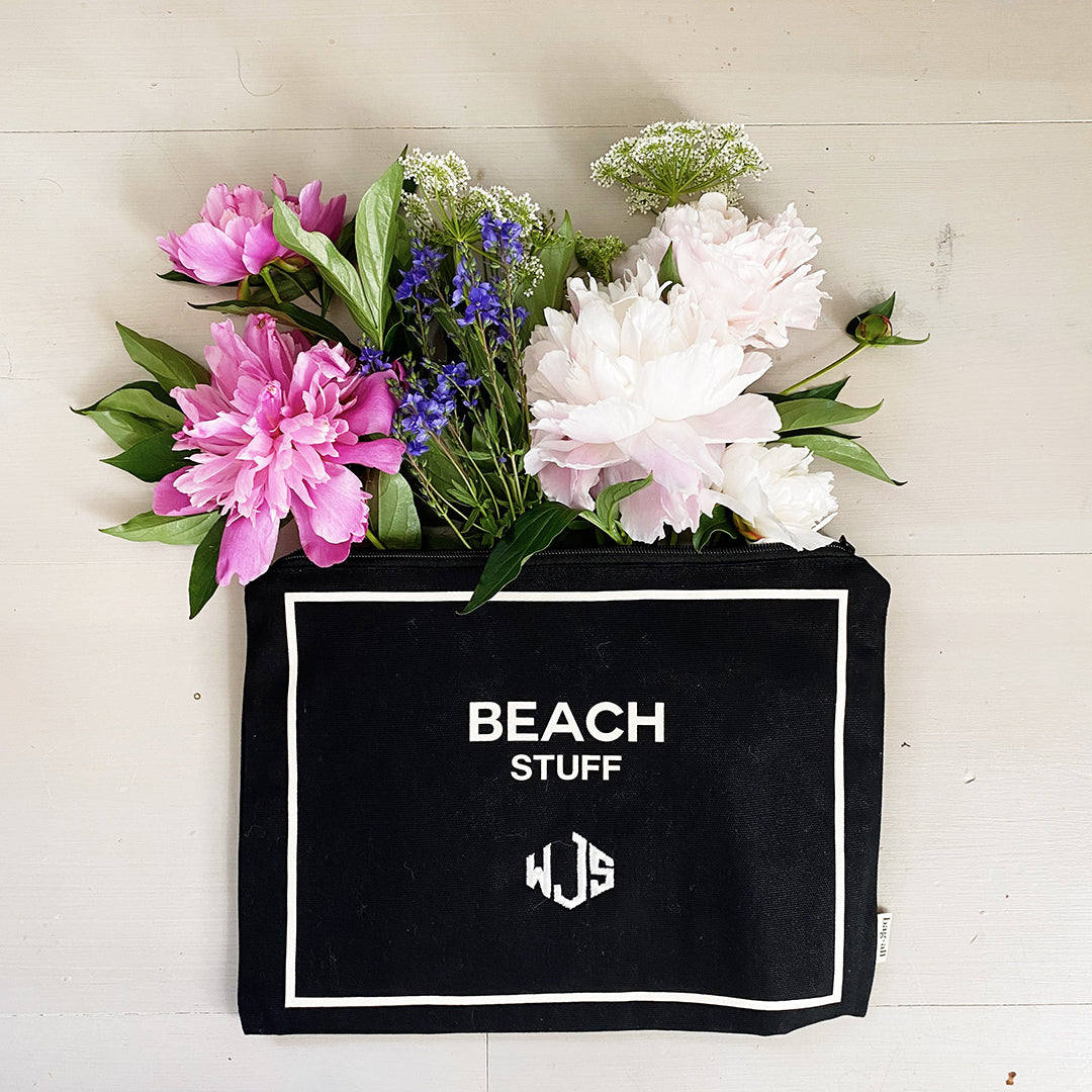 Bag-all monogrammed black beach pouch with white trim displaying 'BEACH STUFF' text, decorated with pink and white peonies and blue delphinium flowers