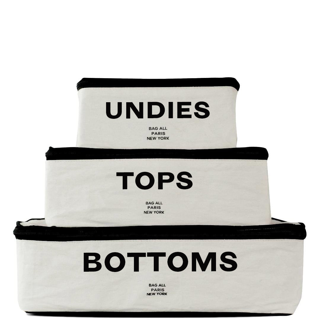 Bag-all Cotton Packing Cubes set of 3 in cream with black trim, labeled Undies, Tops, and Bottoms for organized travel storage, featuring mesh ventilation panel