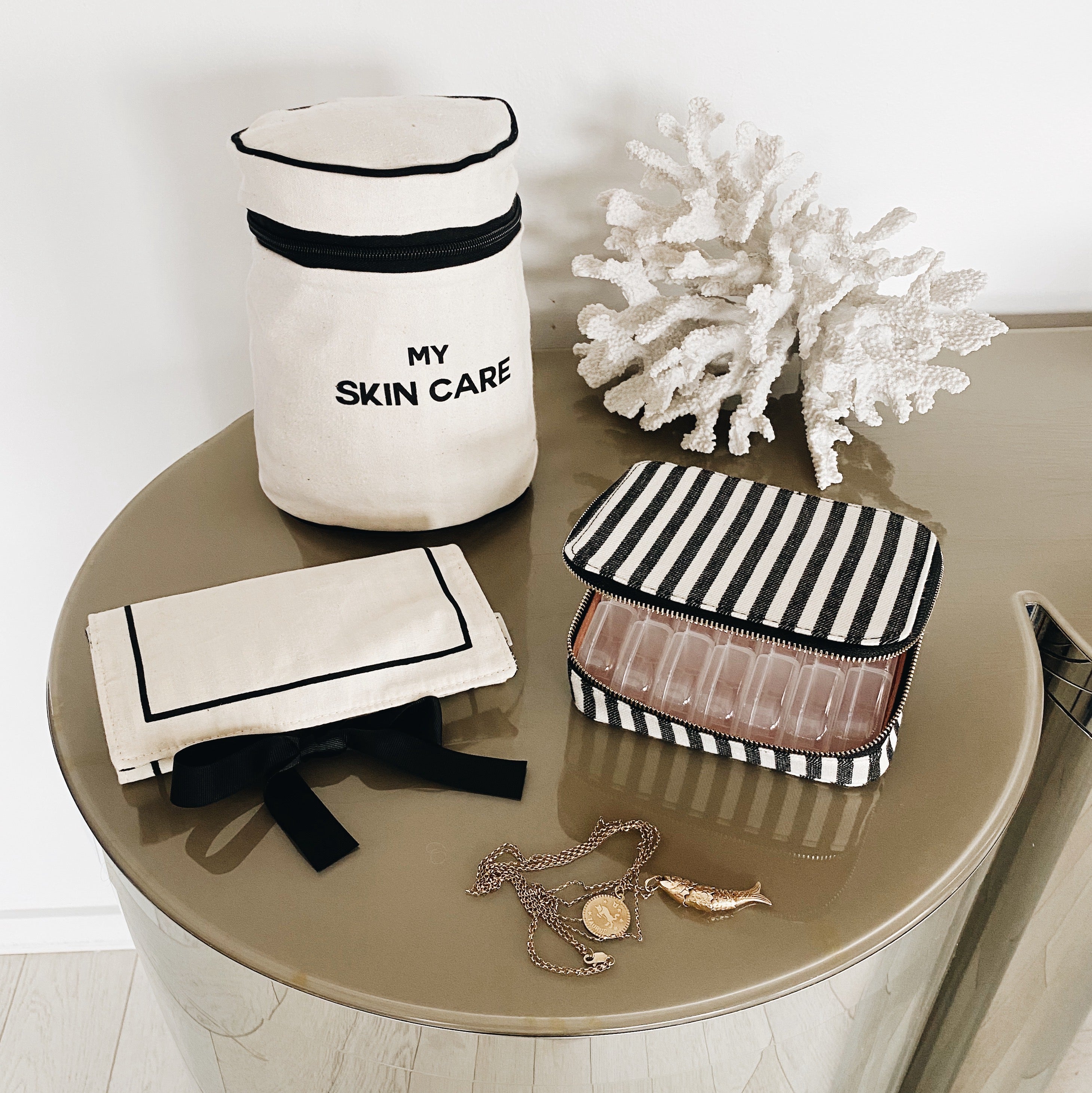 Bag-all Essential Gift Set Deal 3-Pack Cream featuring organizing cases for skincare, pills, and jewelry, displayed on round table with decorative coral, black and white cotton design with elegant stripes and bows