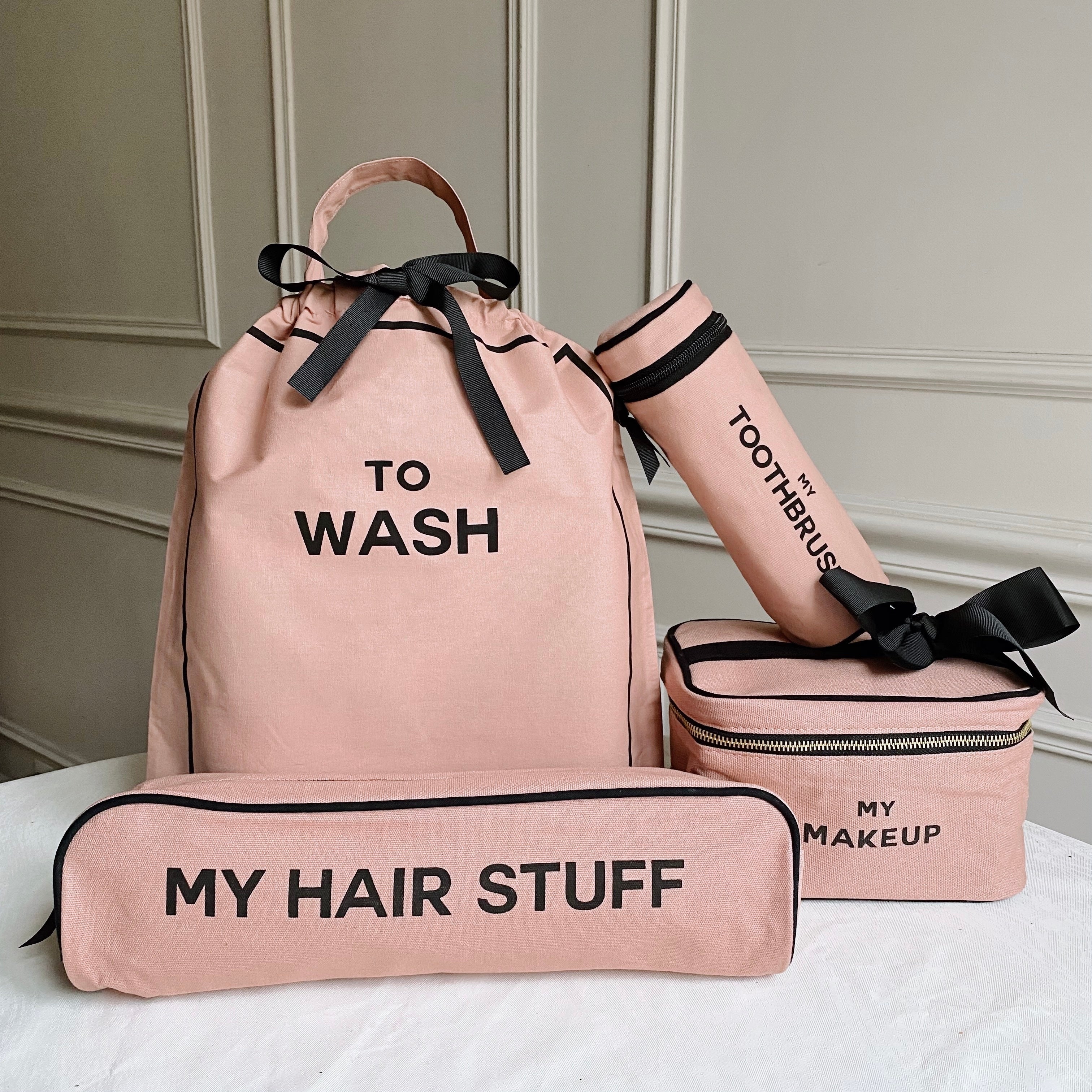 Bag-all Deal Gift Set featuring blush pink cotton travel organizers: To Wash laundry bag, makeup box, hair stuff case, and toothbrush holder with black text and bows
