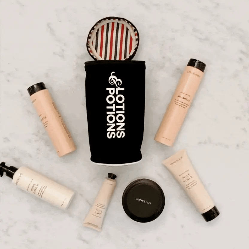 Bag-all Lotions & Potions black travel case displayed with beauty products and toiletries, featuring striped interior lining and white logo text on cotton fabric