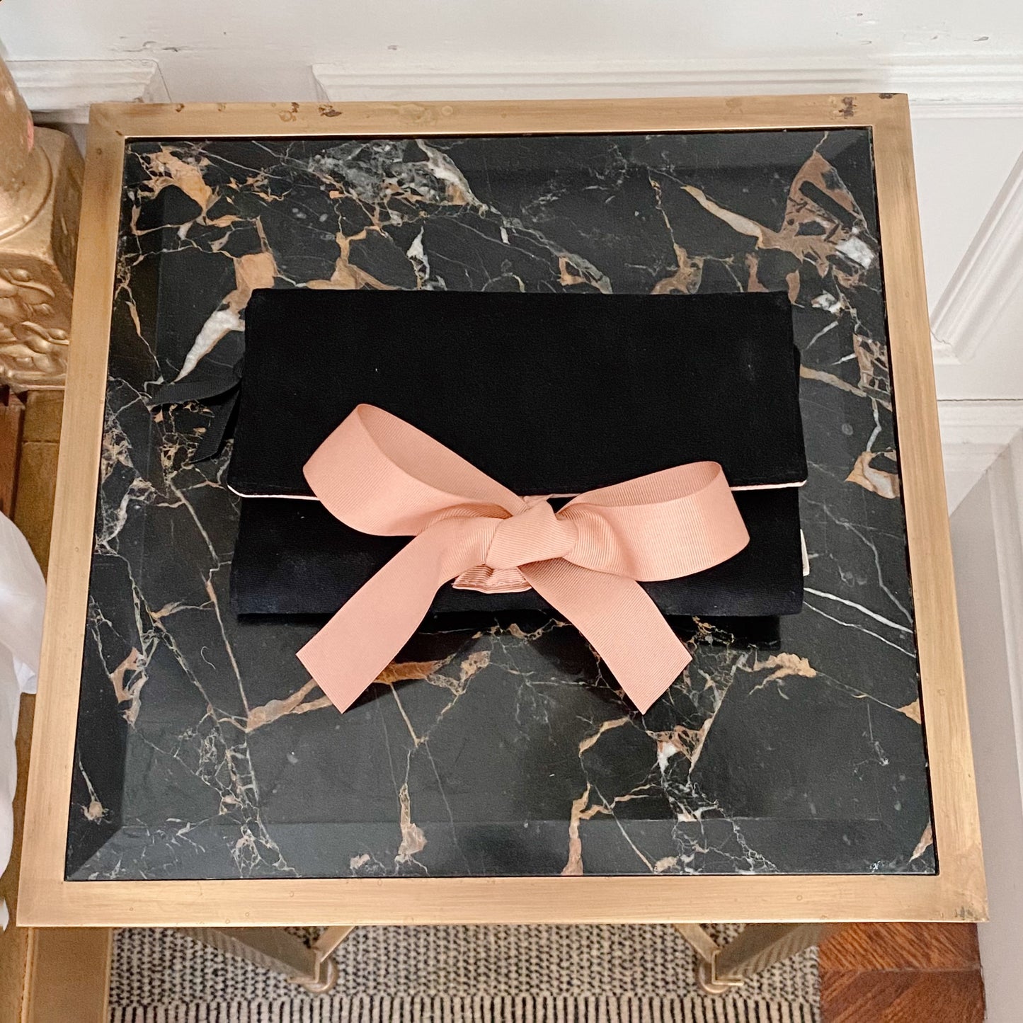 Bag-all Large Jewelry Roll in black with elegant pink bow, displayed on marble surface, stylish travel organizer for precious accessories and bling storage