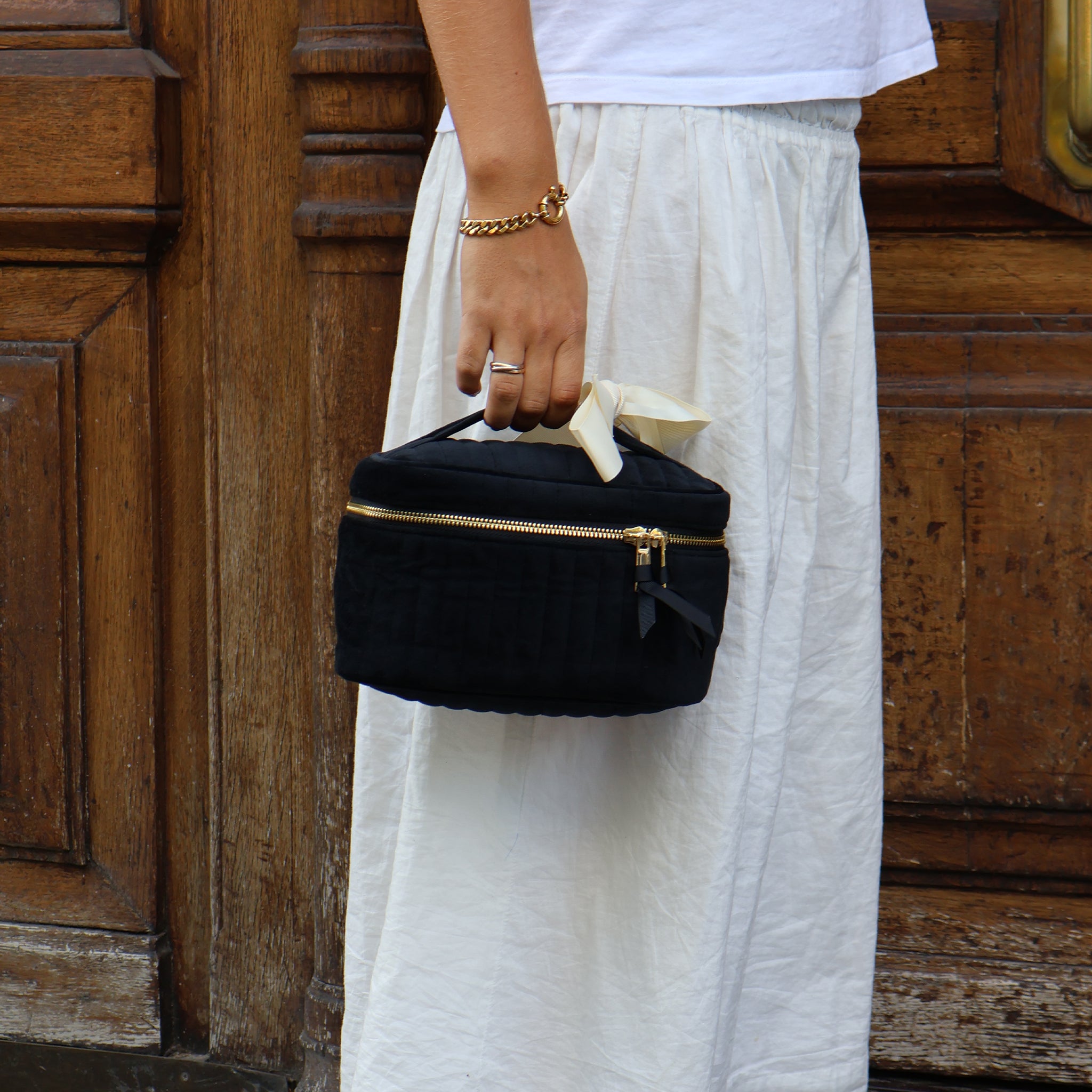 Handheld black quilted velvet cosmetic box by Bag-all with gold zipper, perfect for chic cosmetic organization on the go