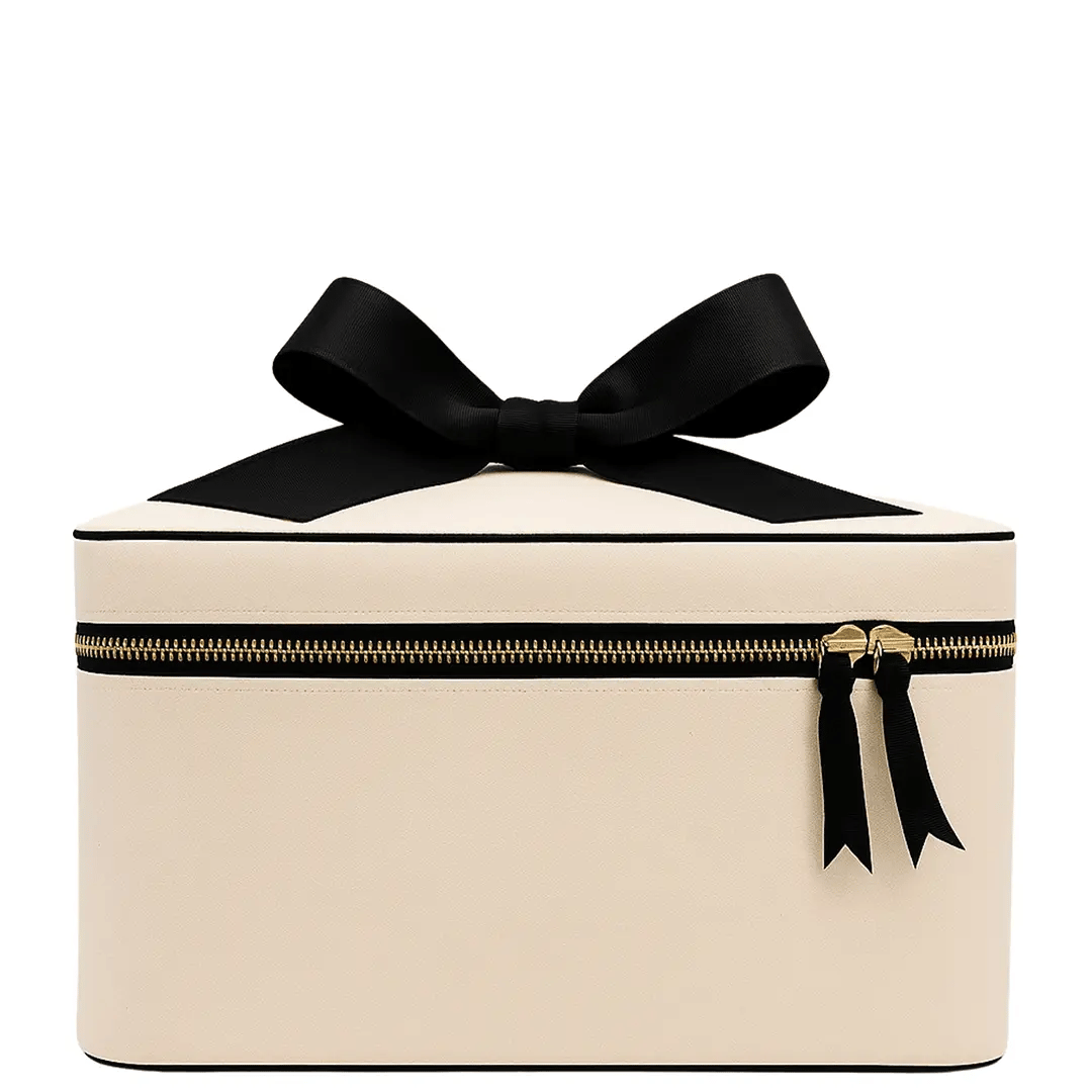 Cream Bag-all medium box makeup and toiletry case with gold zipper and black bow on white background
