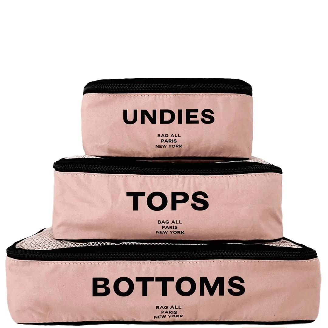 Bag-all pink personalized packing cubes labeled Undies Tops and Bottoms for travel organization
