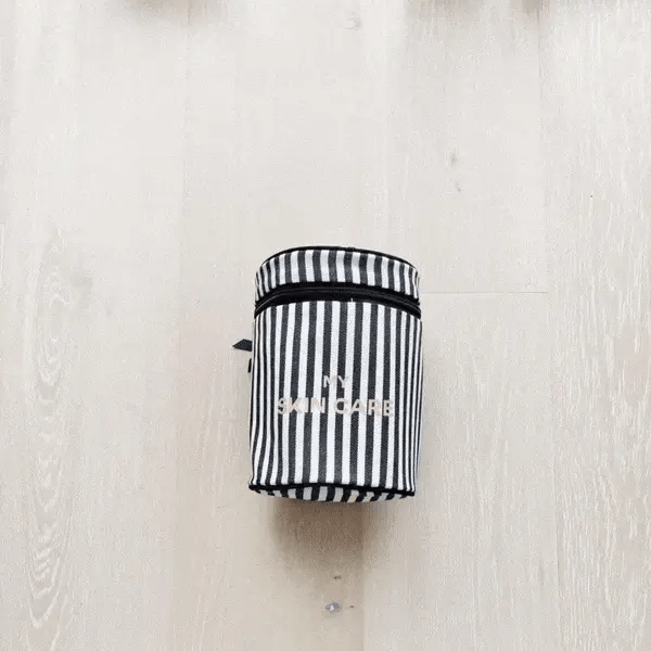Bag-all Round My Skin Care Case in classic black and white stripes, featuring cylindrical design and secure lid for organized skincare storage