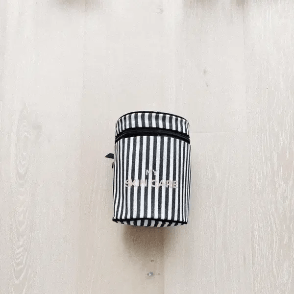 Bag-all Round My Skin Care Case in classic black and white stripes, featuring cylindrical design and secure lid for organized skincare storage