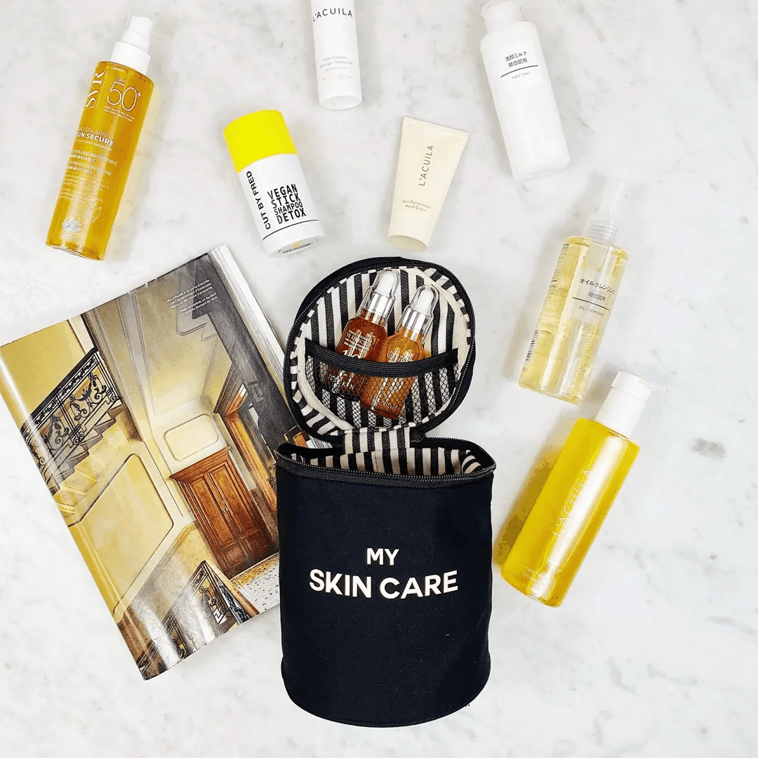 Bag-all black beauty organizer with white My Skin Care print holding skincare bottles and tubes on marble surface