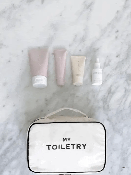 Bag-all Folding/Hanging Toiletry Case in cream with "MY TOILETRY" text, shown with beauty products on marble surface, featuring clean white design and practical handle