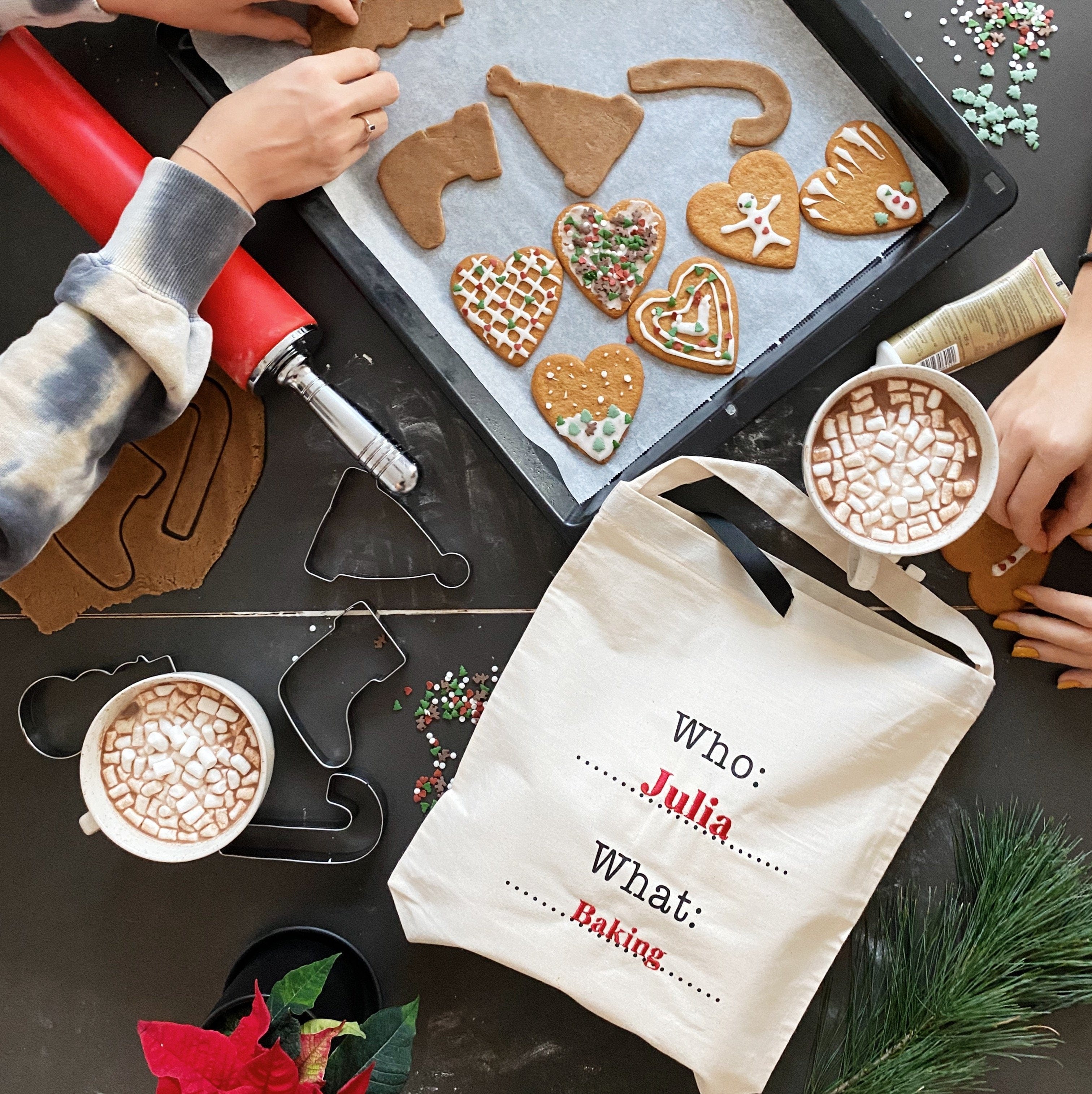 Bag-all Who What Bag in cream shown during holiday baking session with gingerbread cookies, cookie cutters, and hot cocoa. Personalized organization bag displaying baking theme.