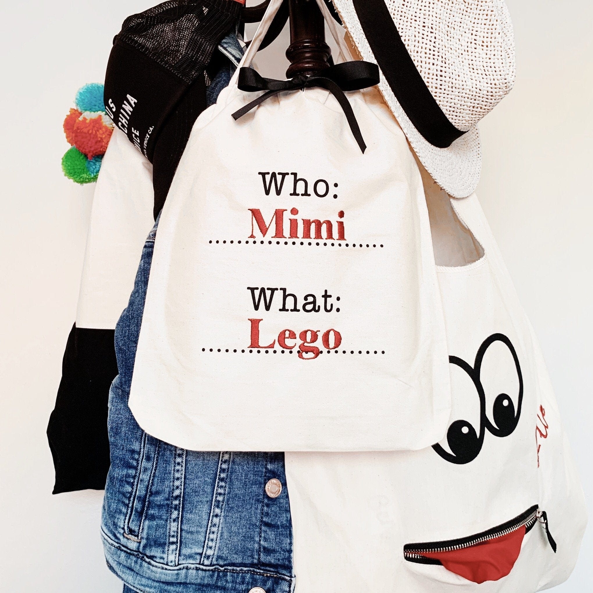 Bag-all Who What Bag in cream cotton featuring personalized text 'Who: Mimi, What: Lego' with black typography, perfect for organizing and storing items in style