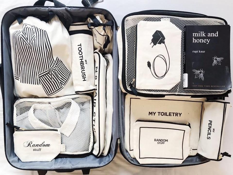 Bag-all Striped Pajamas Travel Bag in cream shown organized in suitcase with other travel storage bags, featuring clean monochromatic design and neat compartment storage