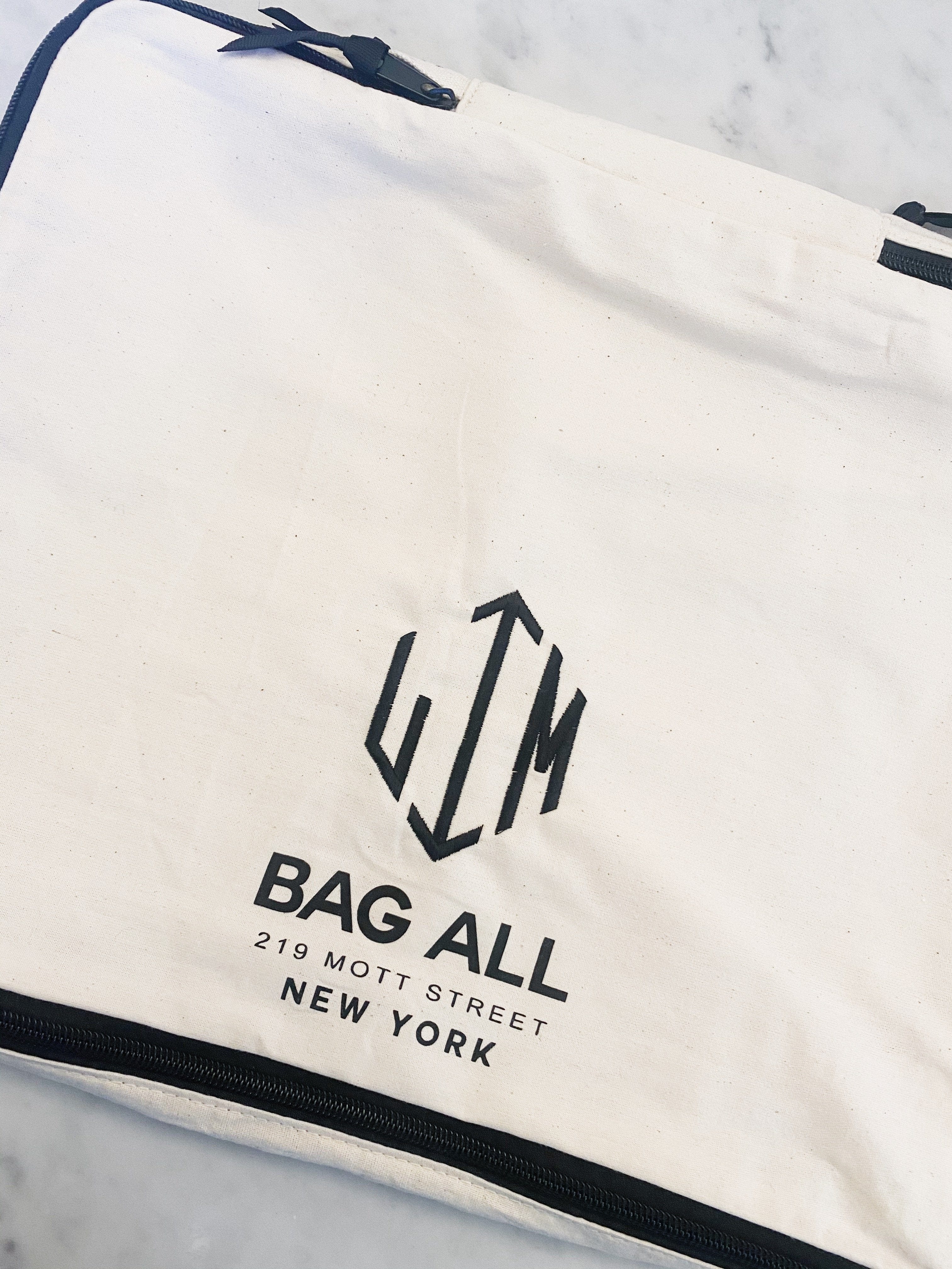 Bag-all Large Packing Cube Double Sided in Cream with hexagonal logo, featuring navy zipper trim and New York store address on clean white cotton canvas