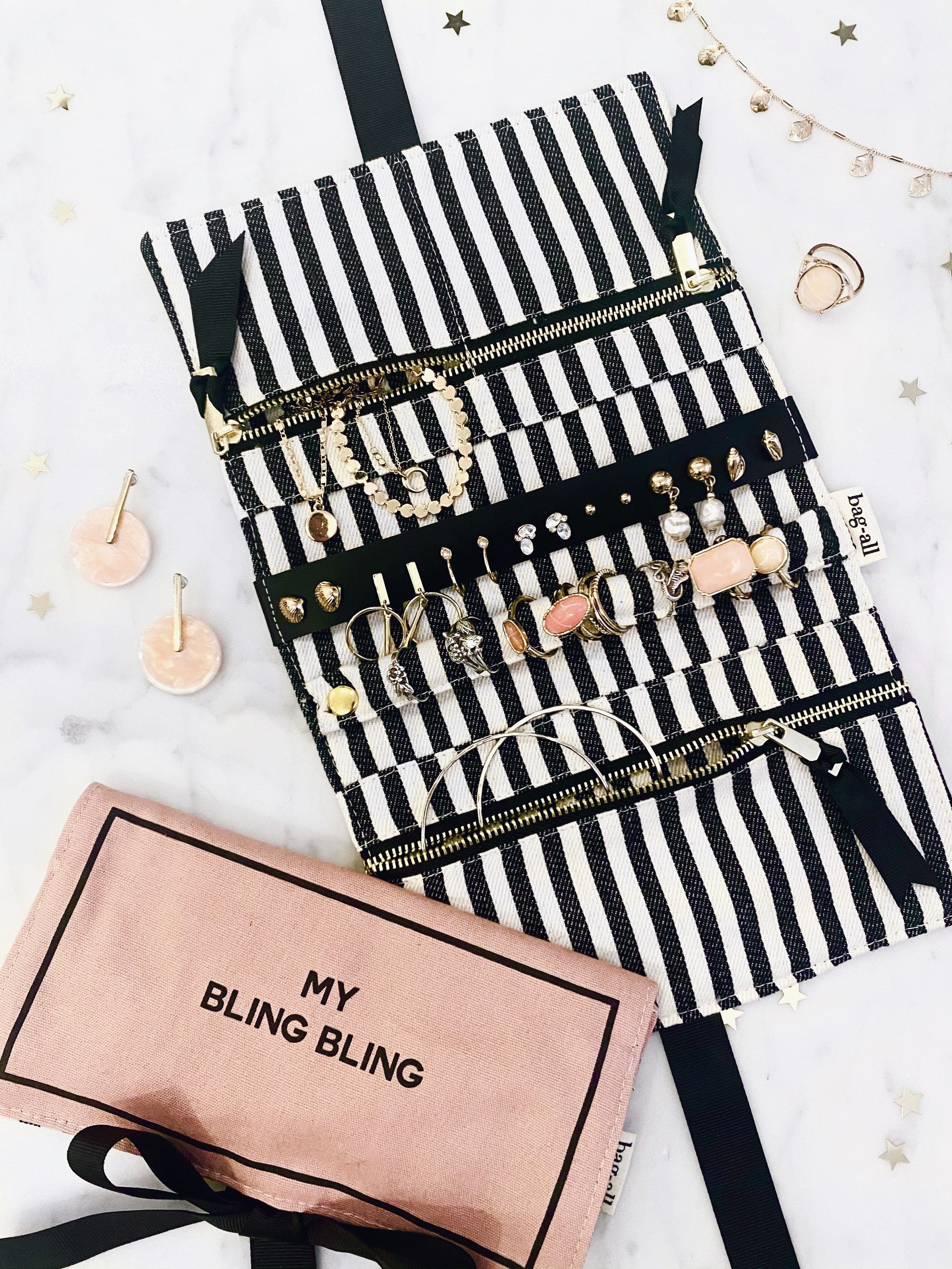 Bag-all Jewelry Organizer Travel Pouch featuring black and white striped interior, multiple compartments displaying organized jewelry, with blush pink case labeled "My Bling Bling" below