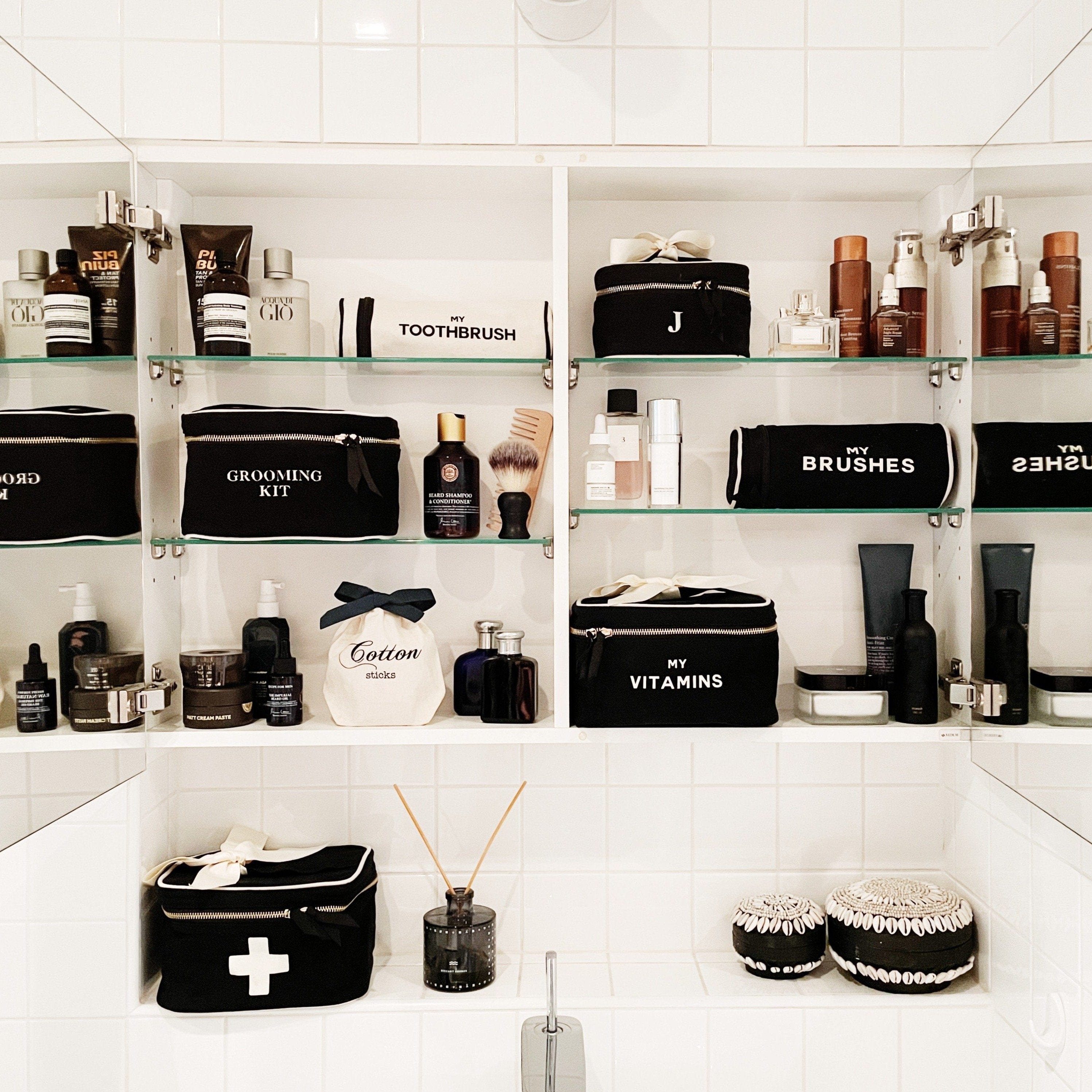 Bag-all Black Vitamins Storage and Travel Box displayed in organized bathroom cabinet alongside matching toiletry cases and grooming essentials on white shelving