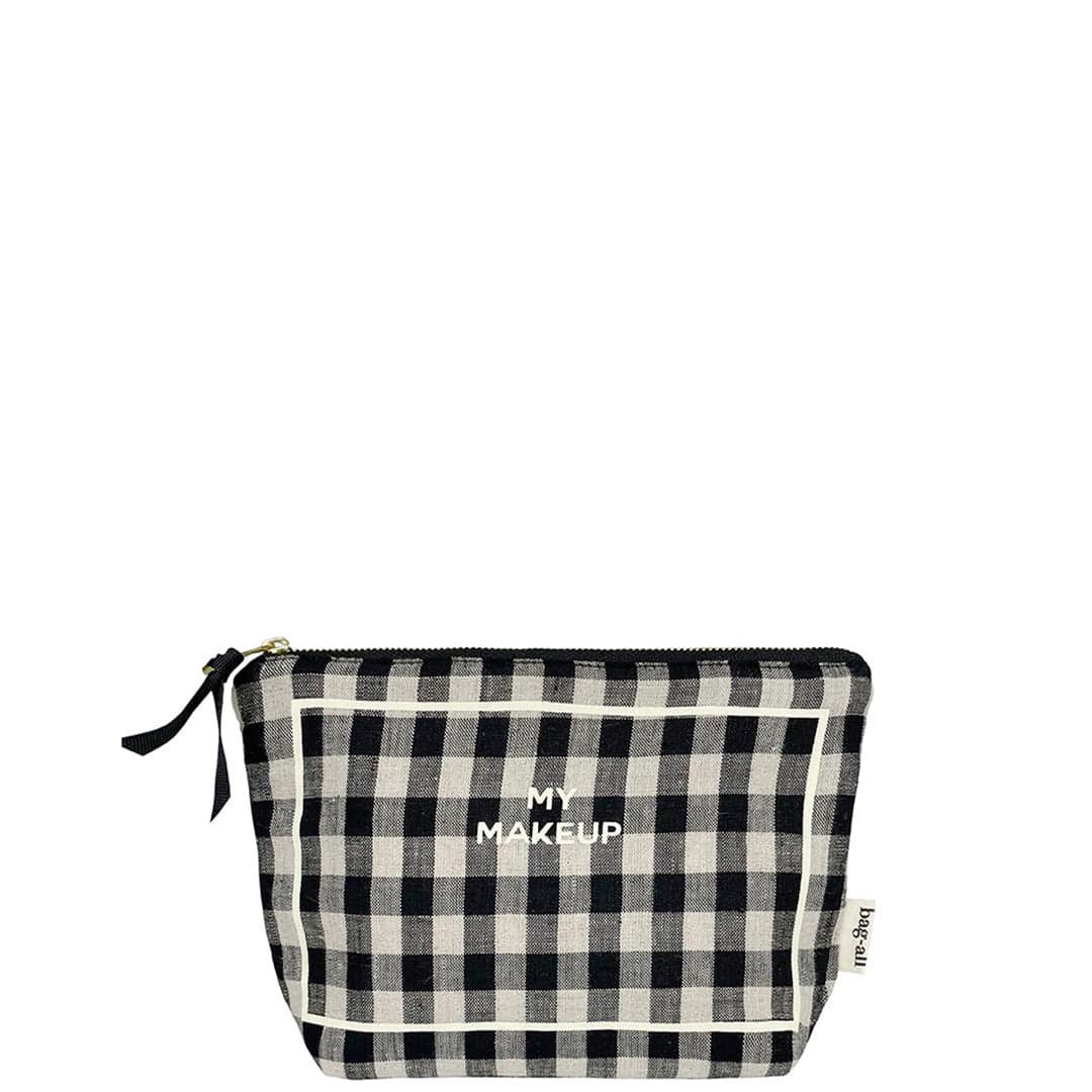 Bag-all My Makeup Pouch in black and white gingham pattern with coated lining, gold zipper and MAKEUP text print. Travel-sized cosmetic case for organizing beauty essentials.