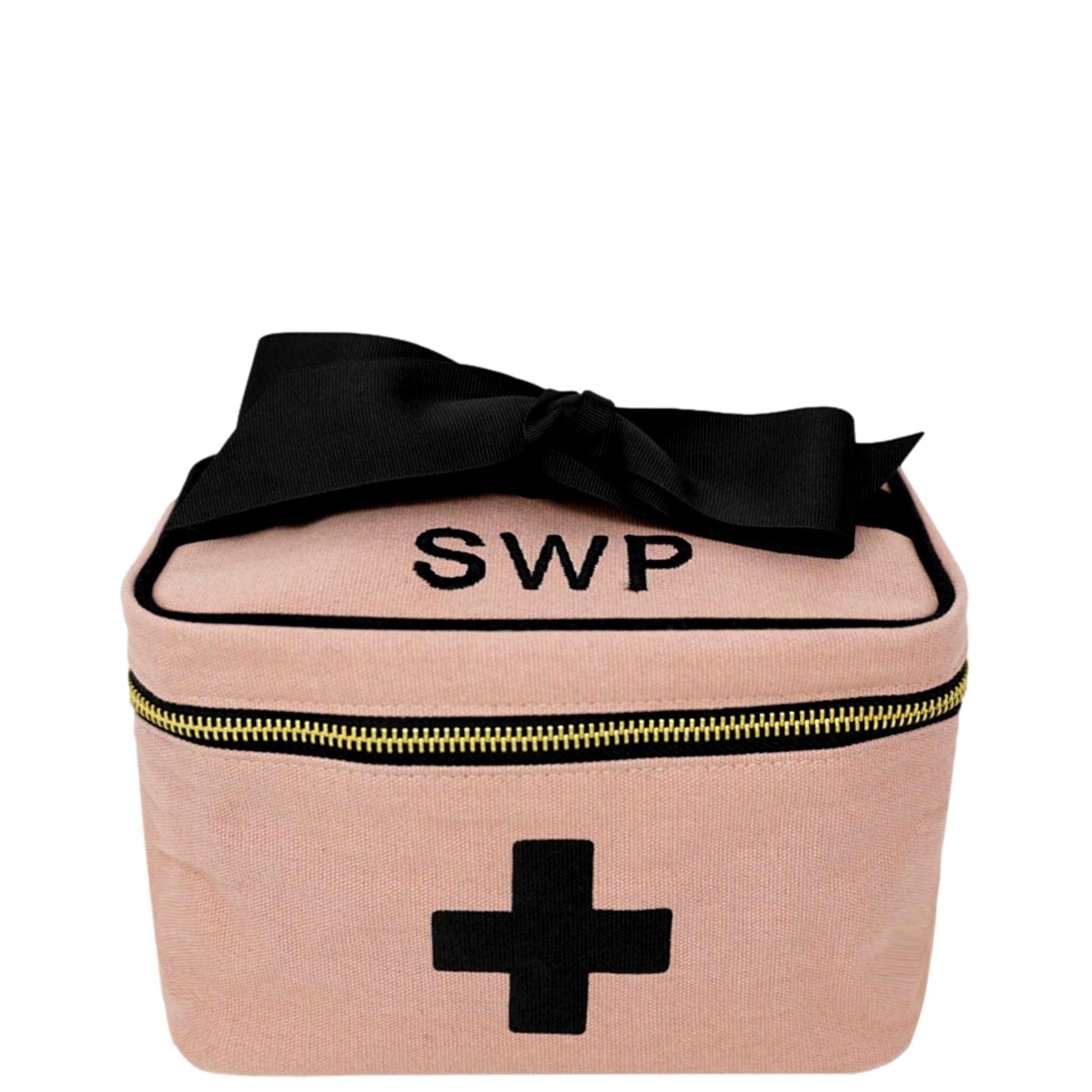 Bag-all Meds and First Aid Storage Box in pink canvas with black cross, monogrammed SWP, black bow accent, gold zipper detail, compact travel-friendly design