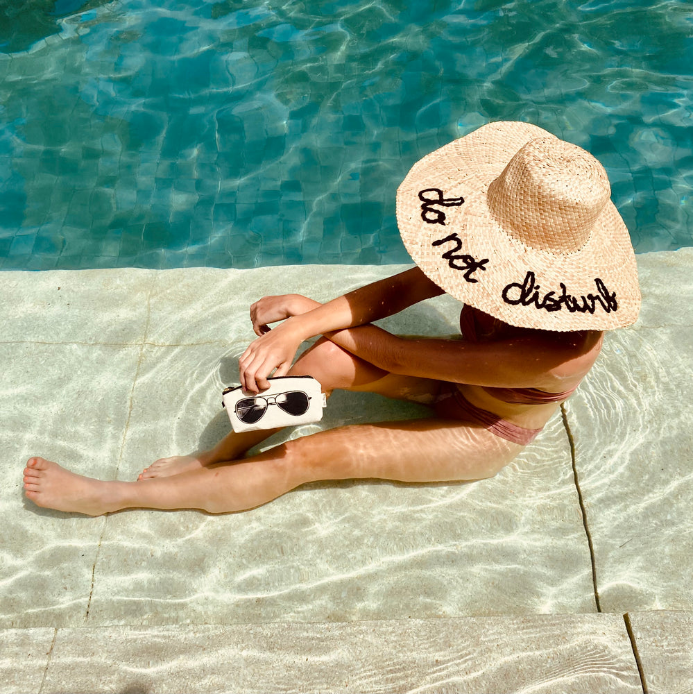 a girl sit in the pool holding a pilot glasses case