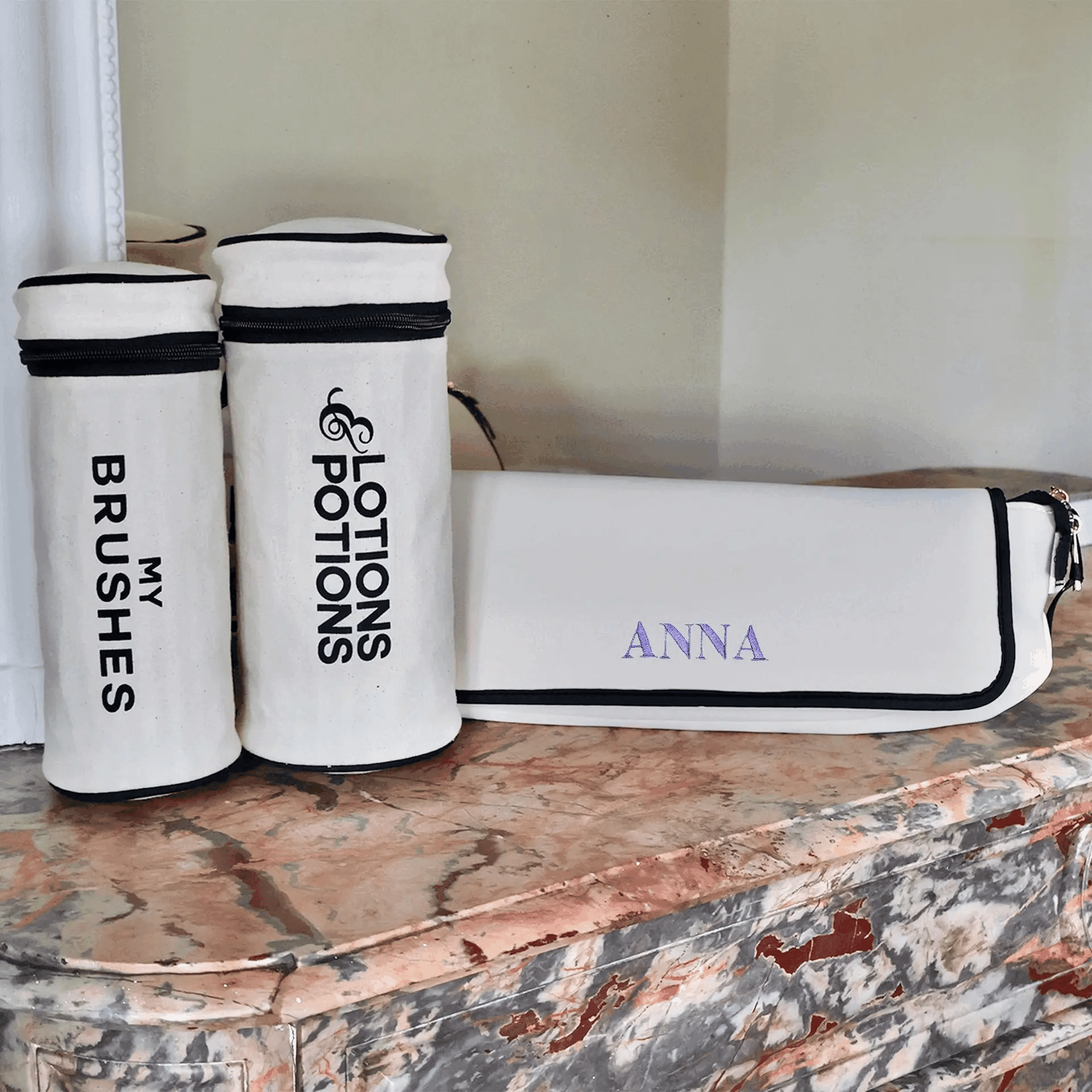 Cream 3-pack brushes and hair tools organizer with zipper closure personalized Anna by Bag-all on marble surface