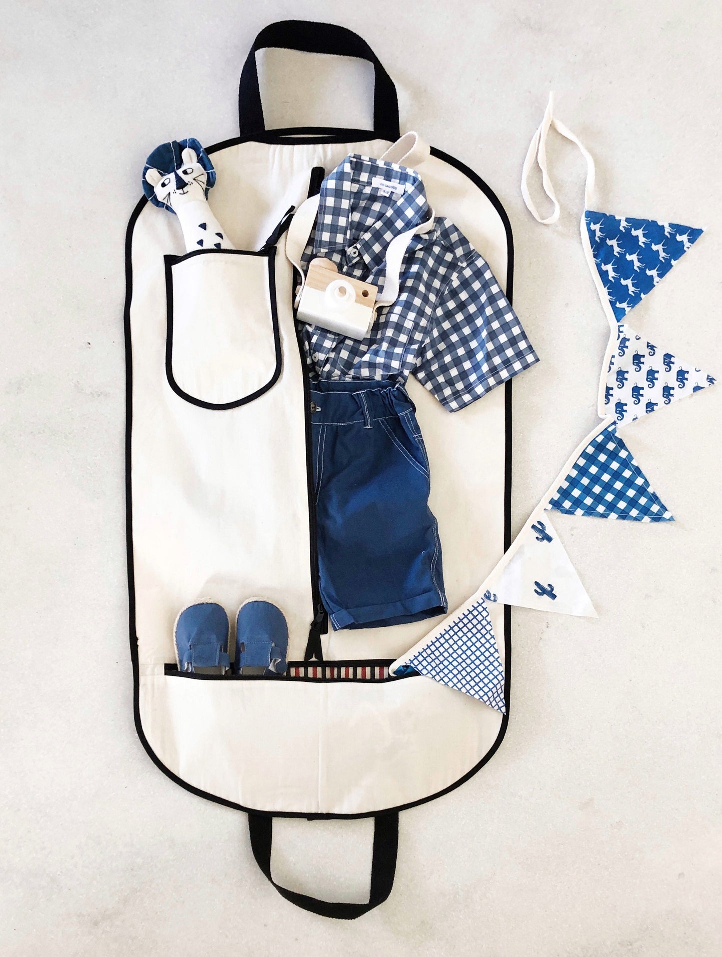 Bag-all Kids Garment Bag Boy in cream with blue outfit display, featuring pockets, black trim, and handles. Perfect for storing and organizing children's clothing and accessories