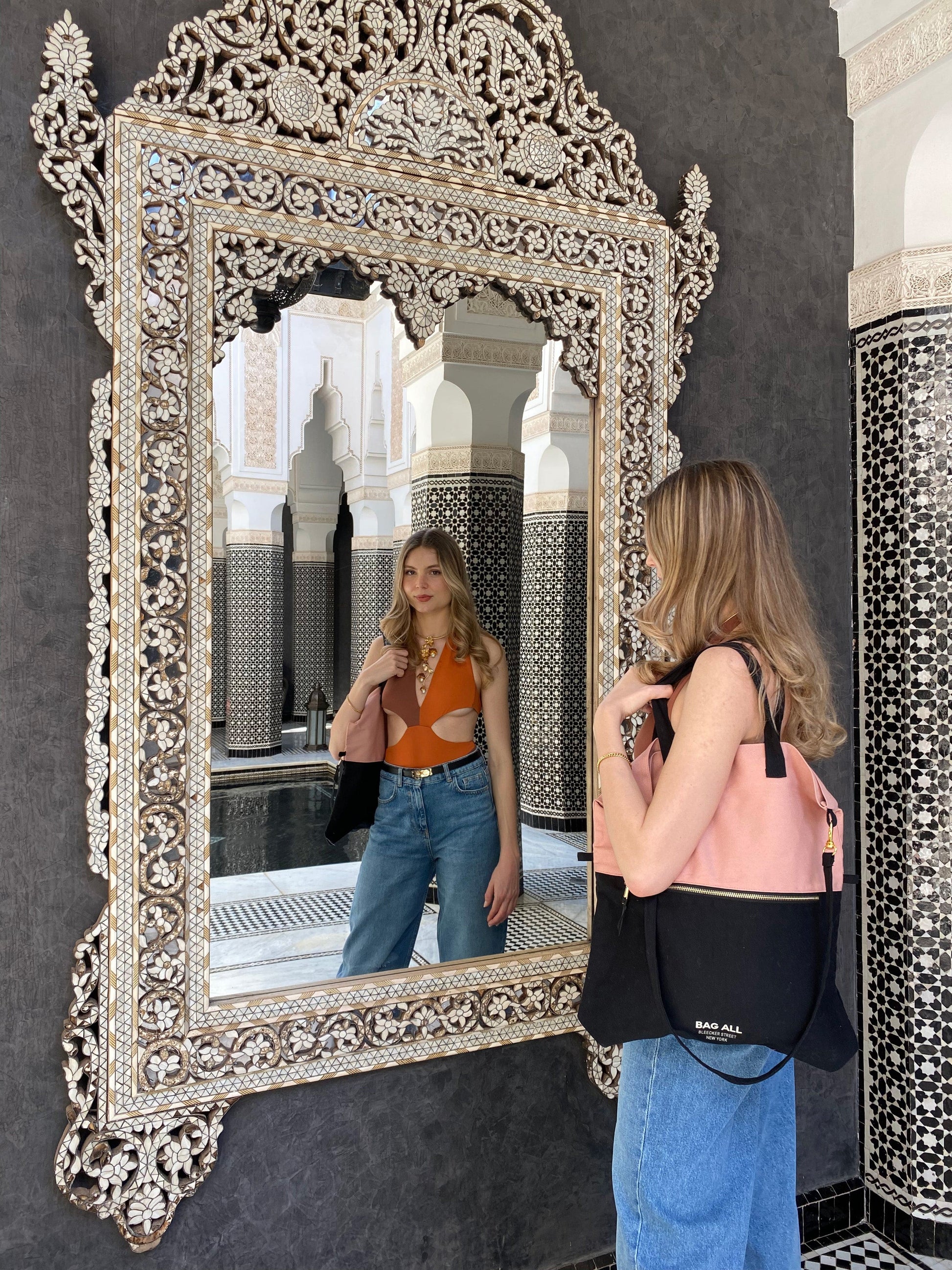 Woman carrying the Bag-all 3-Way Tote in Pink/Black, styled as a handbag. Chic and versatile for travel or everyday use