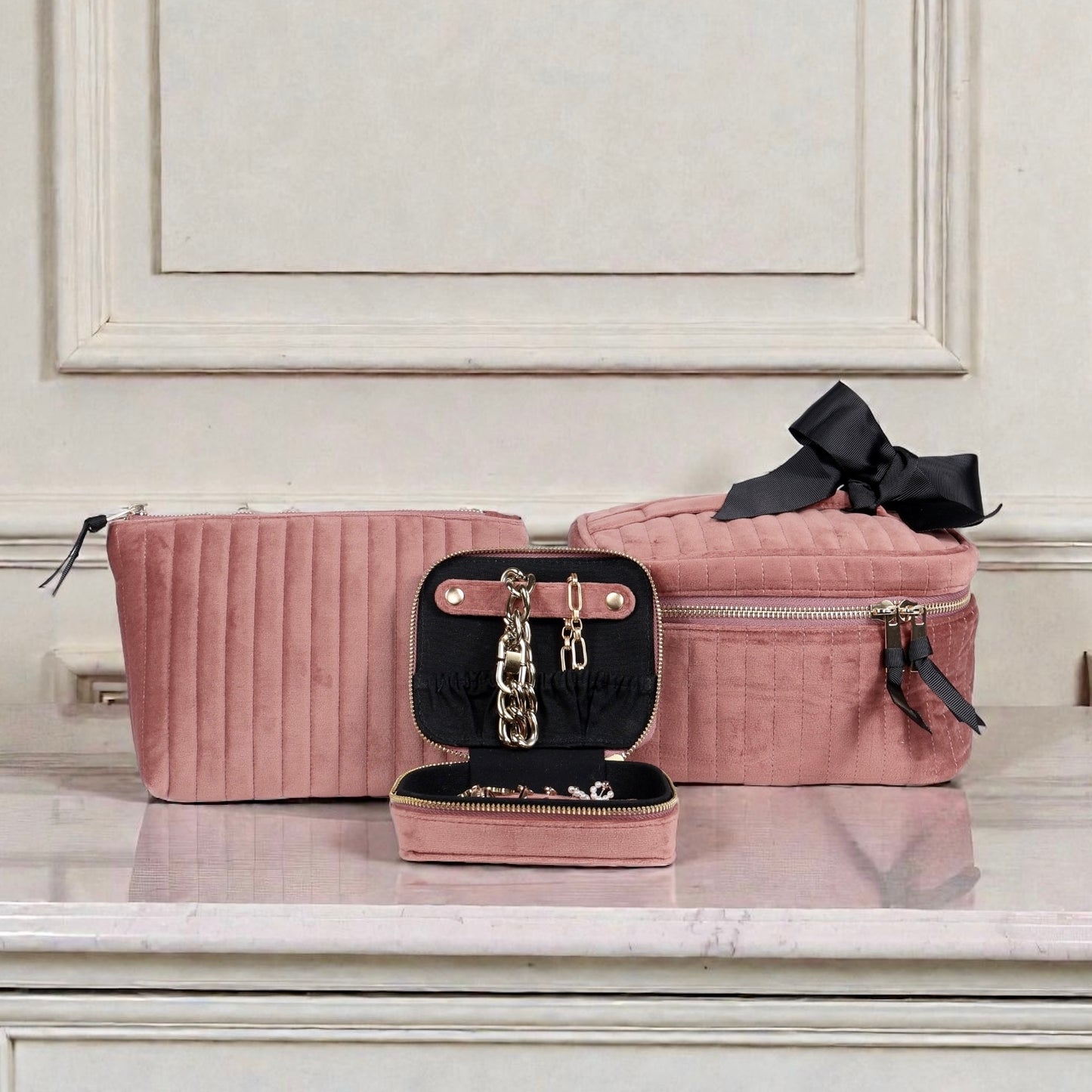 Three-piece Bag-all eco-velvet pink makeup and jewelry storage set with quilted texture on marble surface