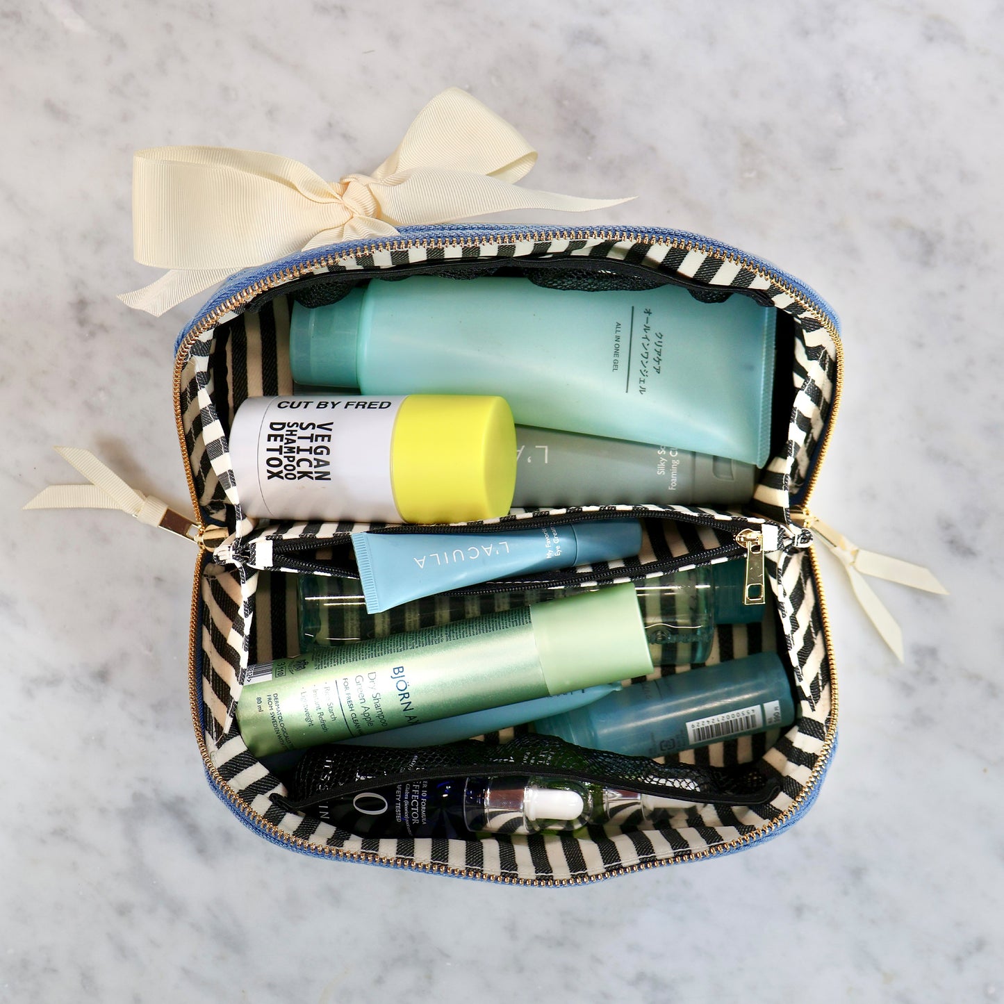 Bag-all Accordion Box Makeup & Toiletry in denim with striped interior holding skincare and beauty products neatly organized