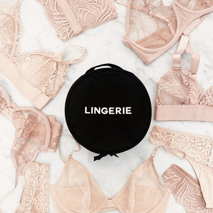 Black Round Lingerie Case by Bag-all surrounded by delicate nude lace bras and panties on white background