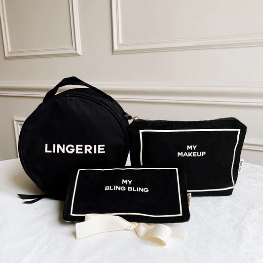 Three black Bag-all pouches labeled Lingerie, My Makeup, and My Bling Bling on white surface with wall panels behind