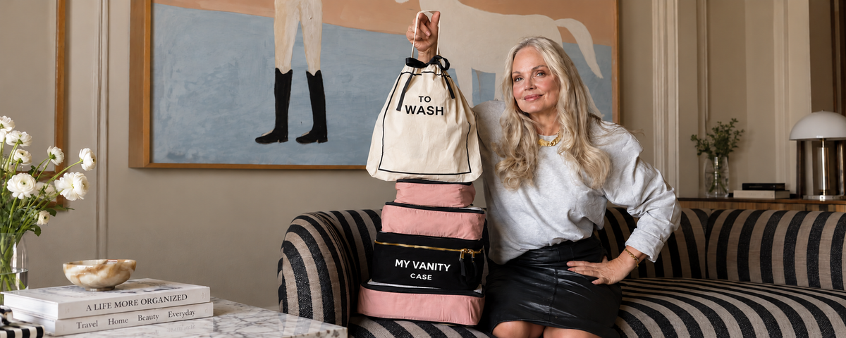 Bag-all travel organization bags including a wash bag and vanity case beside a woman at home