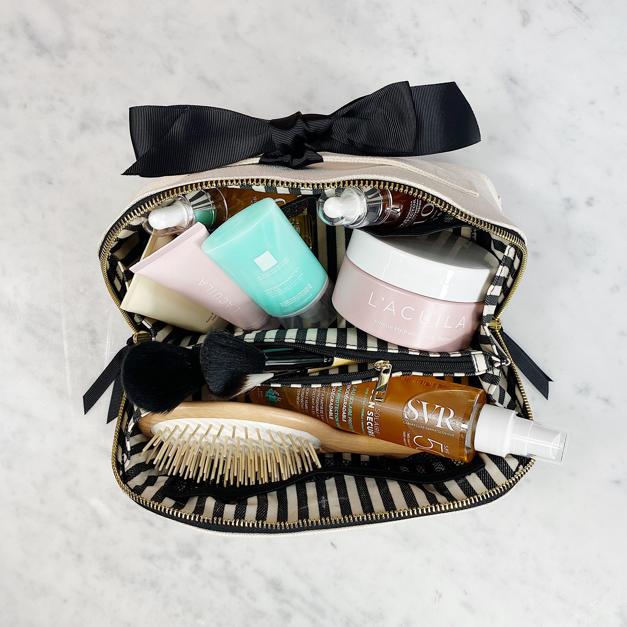Bag-all cream suitcase organizer filled with skincare, brush, and travel essentials for organized packing and storage