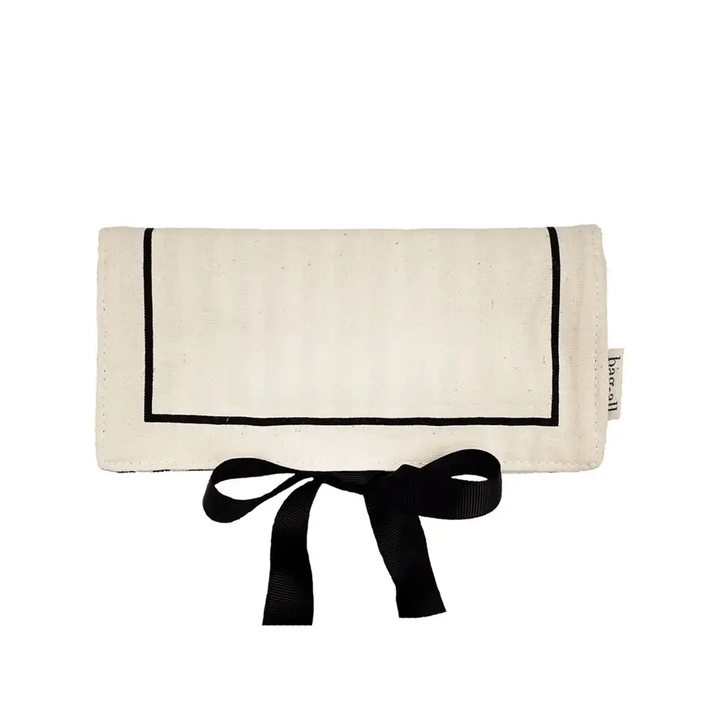 Cream medium Couture Jewelry Roll with black trim and ribbon tie by Bag-all on white background