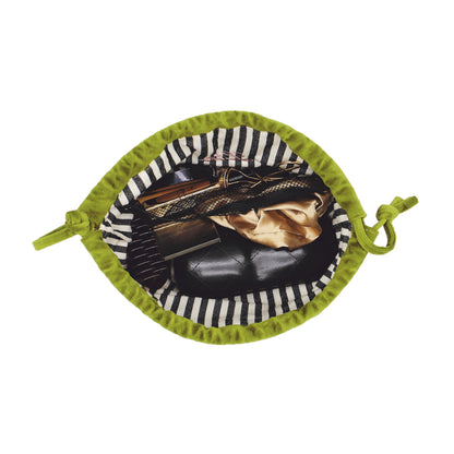 Open green velvet drawstring bag with striped lining holding makeup items by Bag-all for easy organization and travel