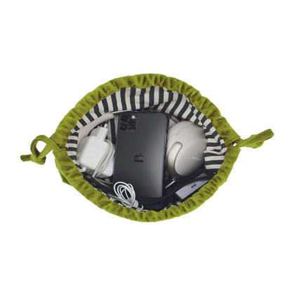 Green velvet drawstring pouch with tech essentials organized inside by Bag-all, perfect for earbuds and chargers storage