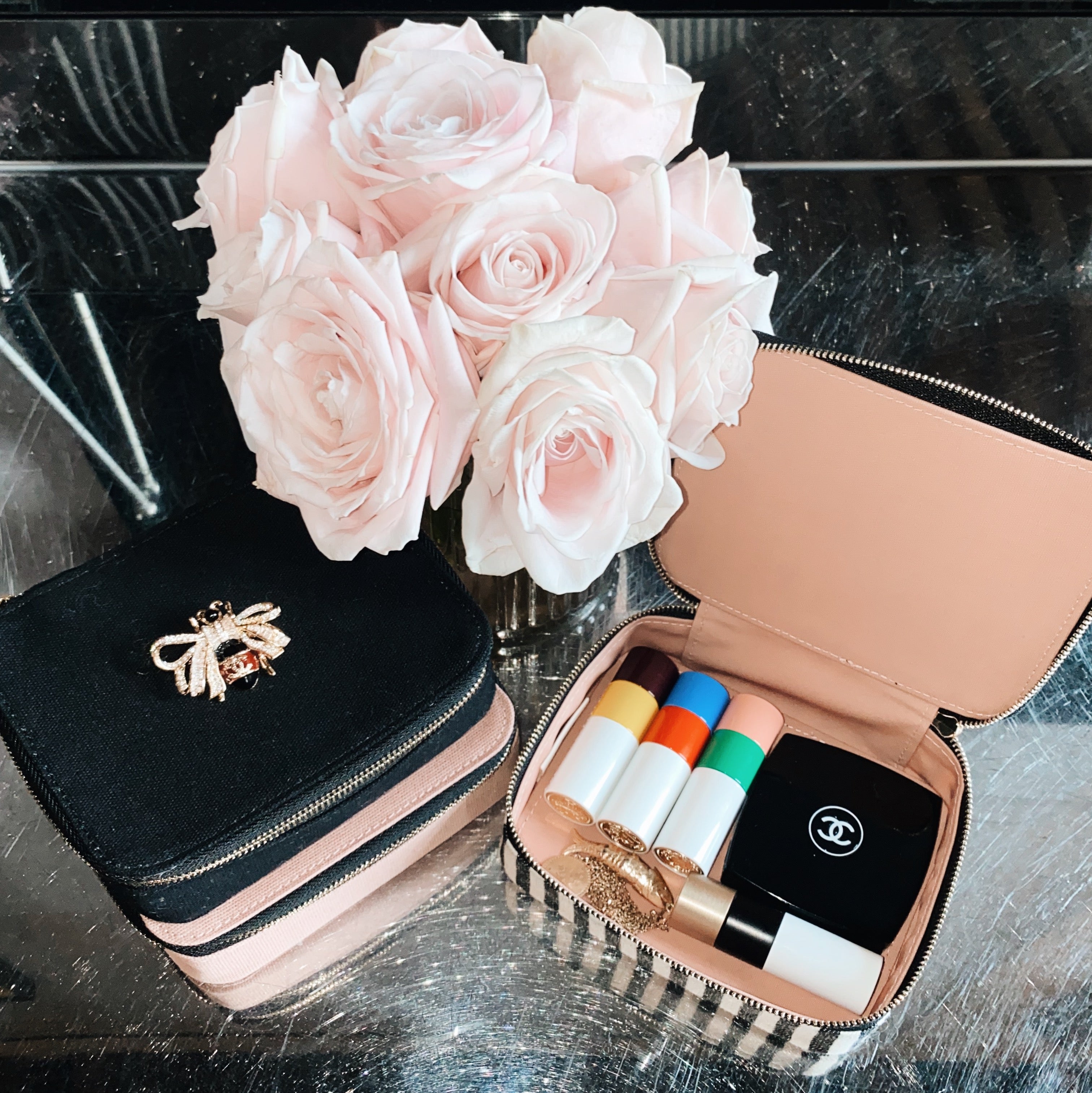 Bag-all Cosmetics/Trinket Box with striped design shown open displaying makeup items, alongside elegant pink roses and matching accessories on black surface