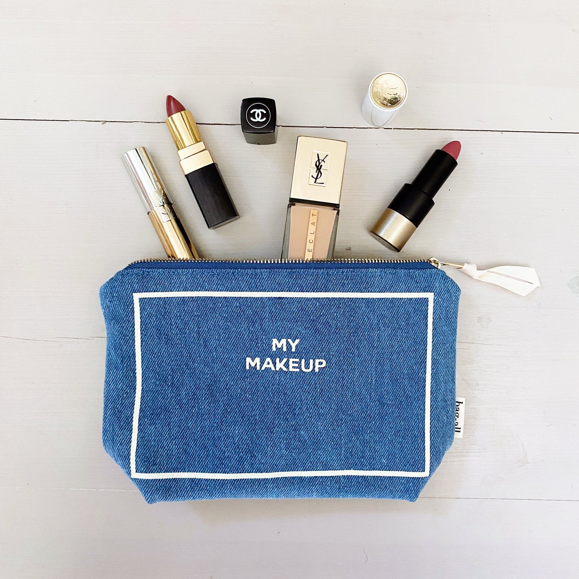 Denim cosmetic organizer with zipper, labeled My Makeup, holding luxury lipsticks and foundation by Bag-all