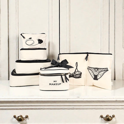 Set of natural cotton Bag-all travel organizers with black trim including lingerie, makeup, tech, and cream pouches