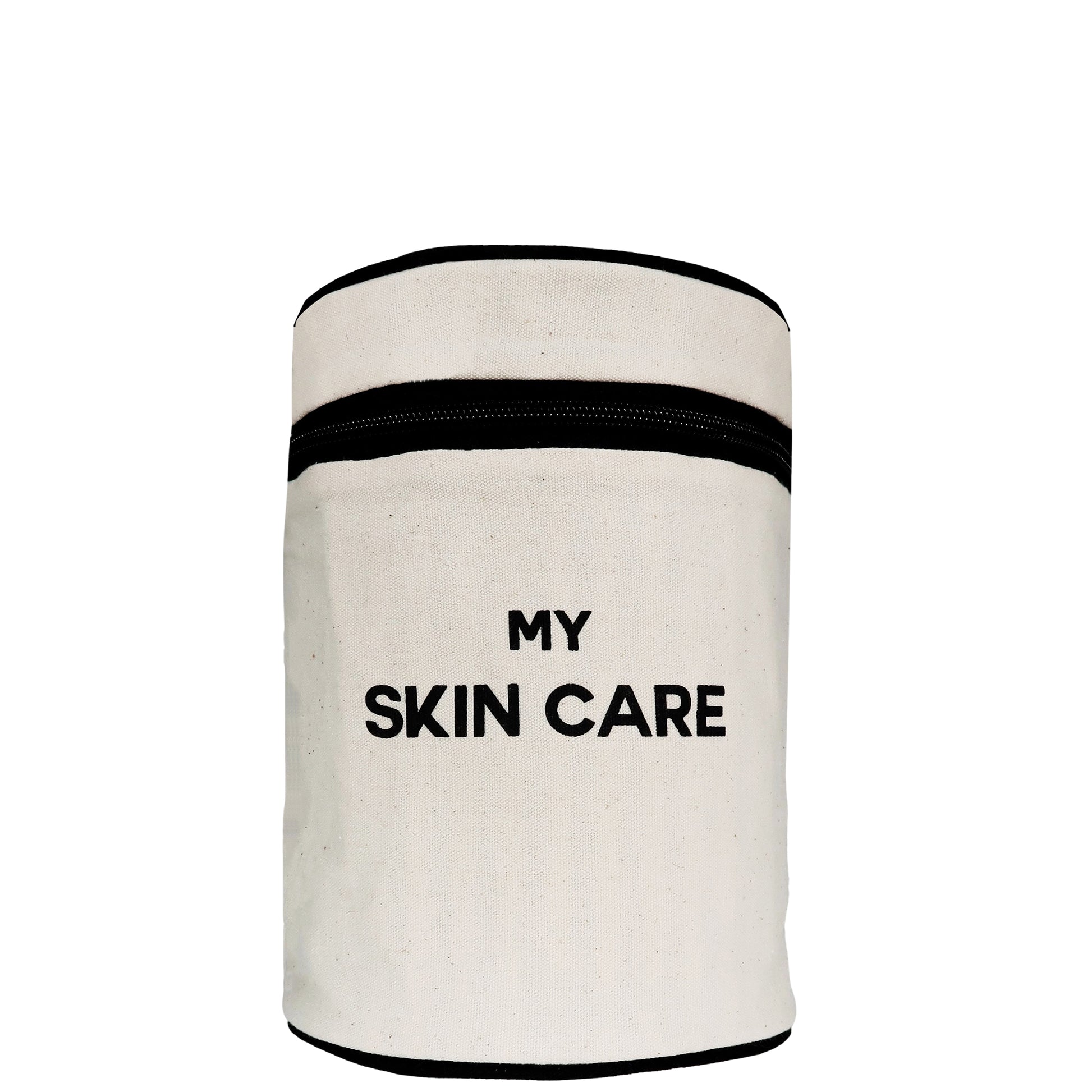 Bag-all Round My Skin Care Case in cream canvas with black trim, featuring cylindrical design and bold text, perfect for organizing beauty products