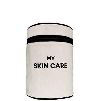 Bag-all Round My Skin Care Case in cream canvas with black trim, featuring cylindrical design and bold text, perfect for organizing beauty products