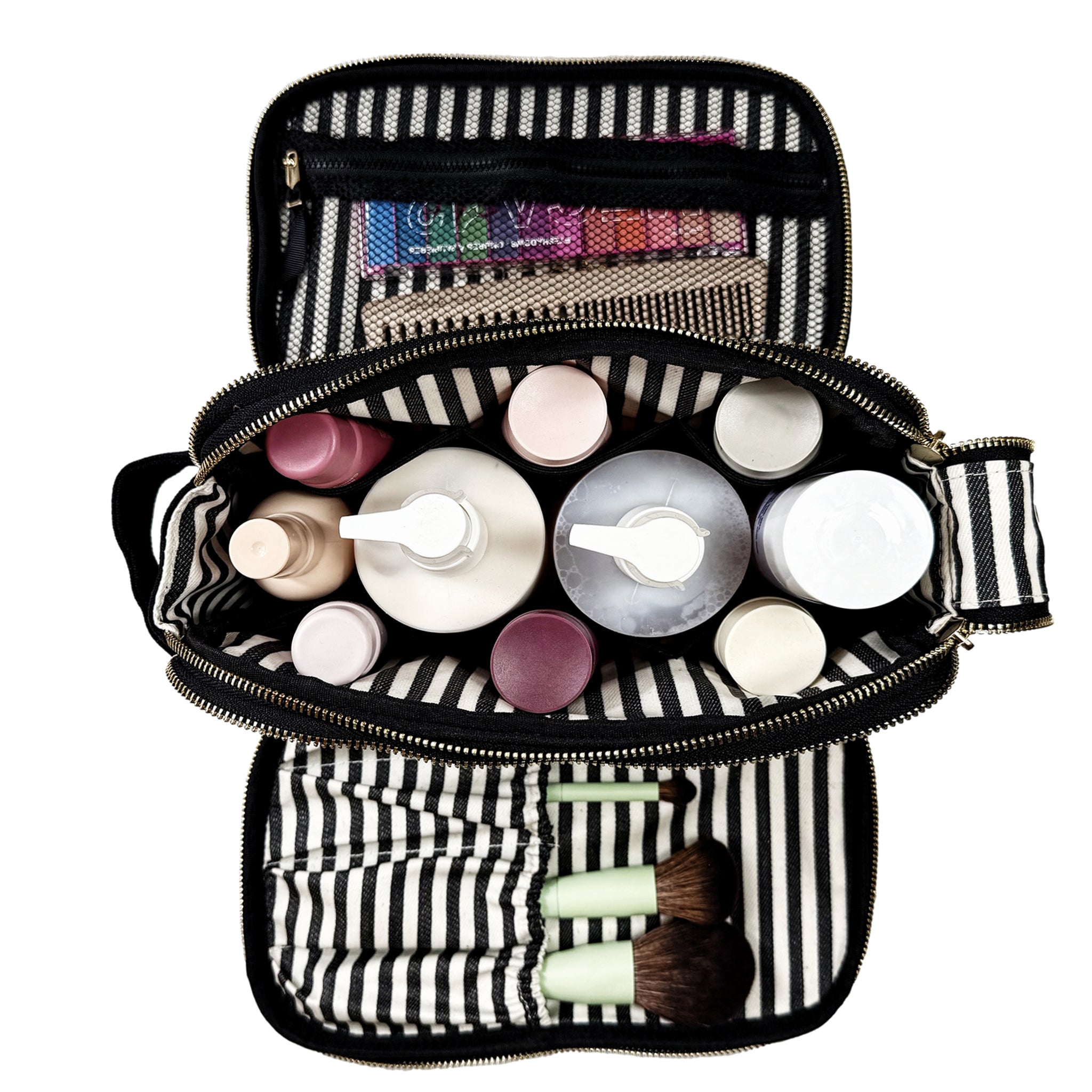 Open black and white striped Bag-all toiletry organizer with bottles, brushes, and makeup tools neatly packed inside