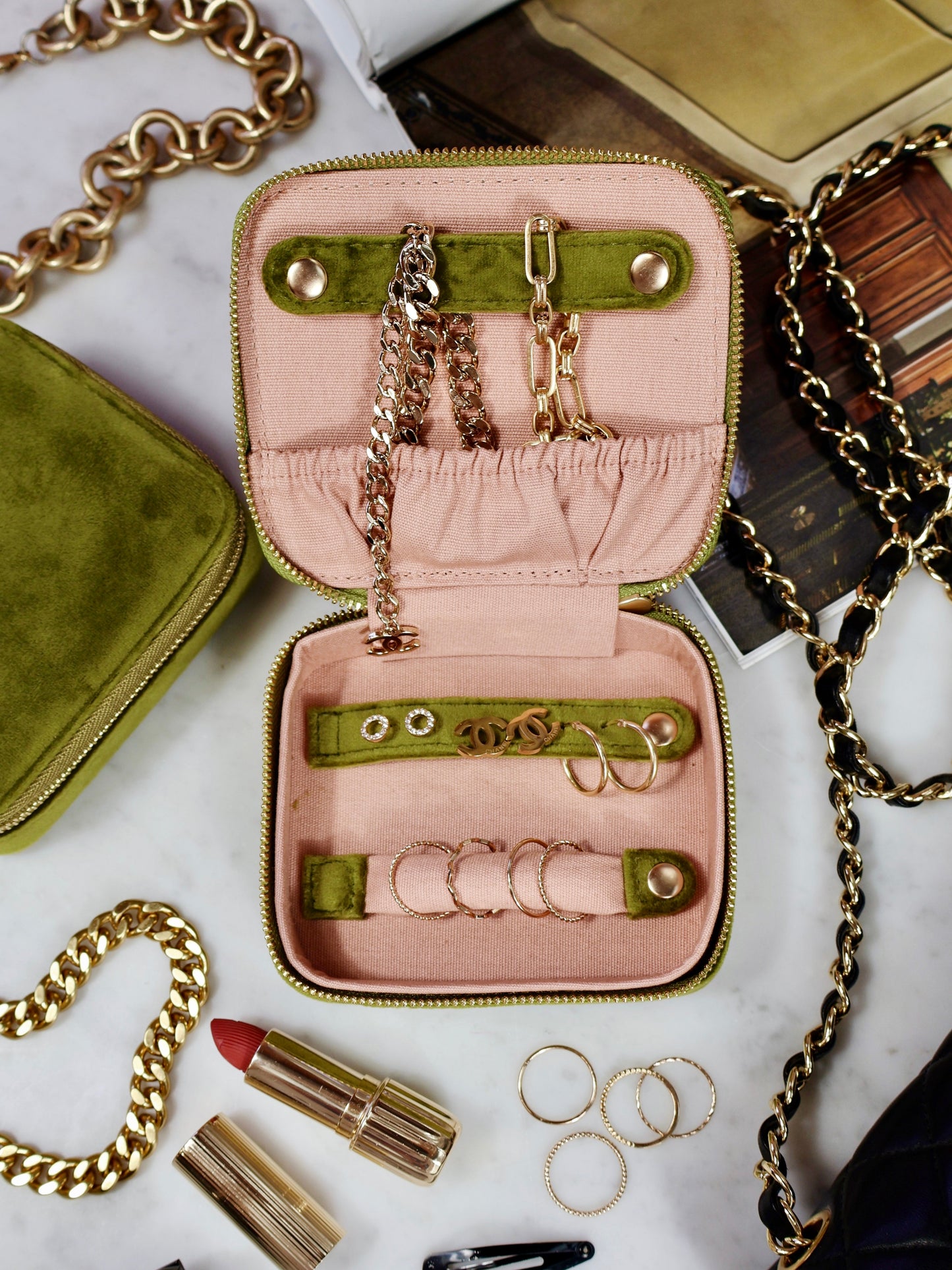 Open eco velvet jewelry case in green and pink with gold chains and rings by Bag-all
