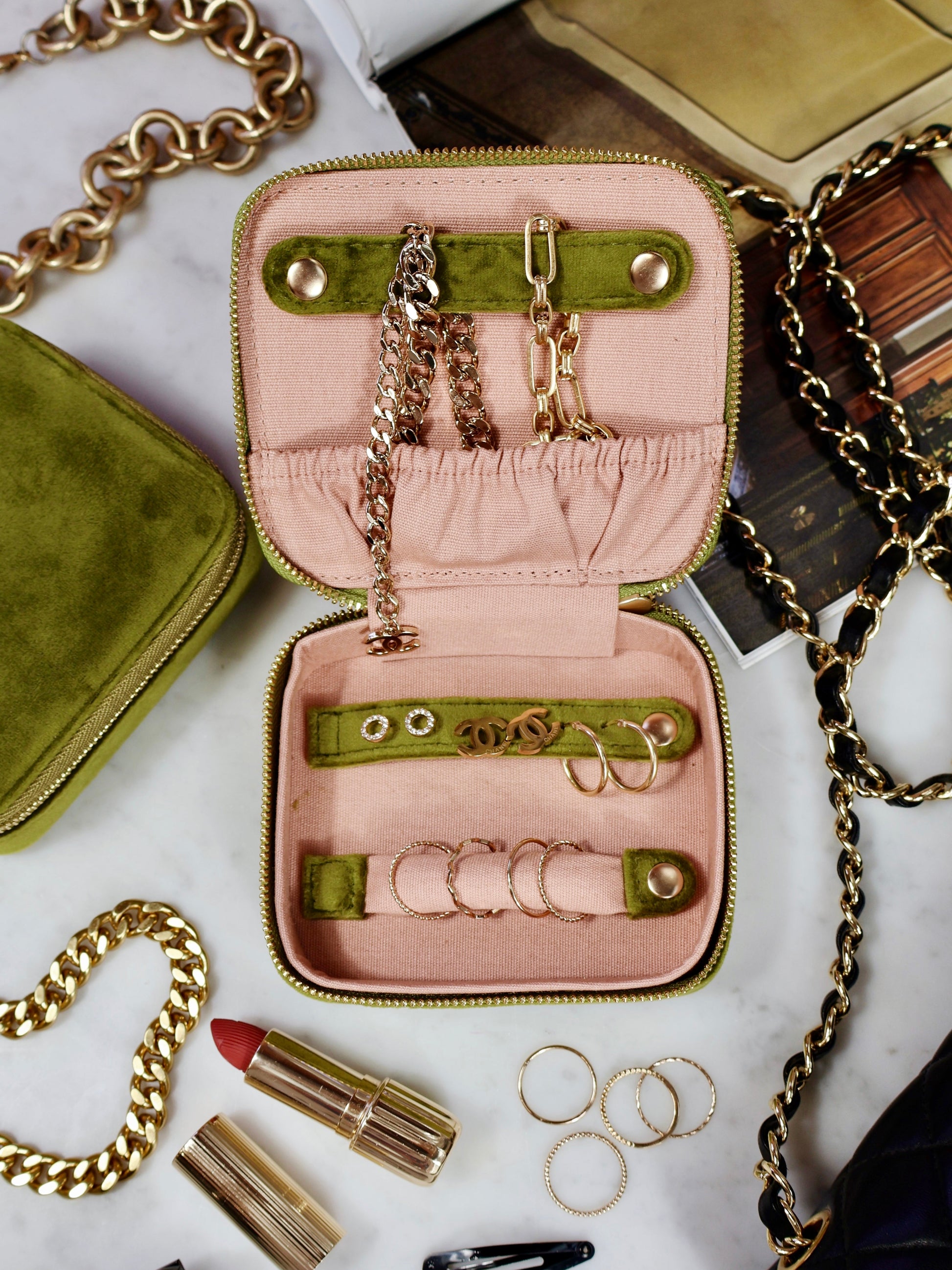 Open eco velvet jewelry case in green and pink with gold chains and rings by Bag-all