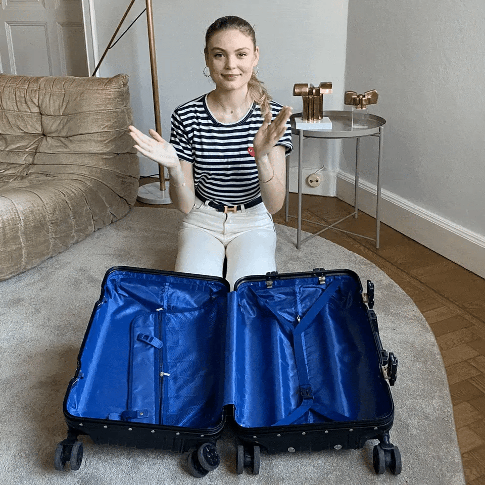 Woman packing a suitcase using the Bag-all BA Travel Set, 8-Pack in Black. Includes packing cubes, shoe, laundry, and tech organizers