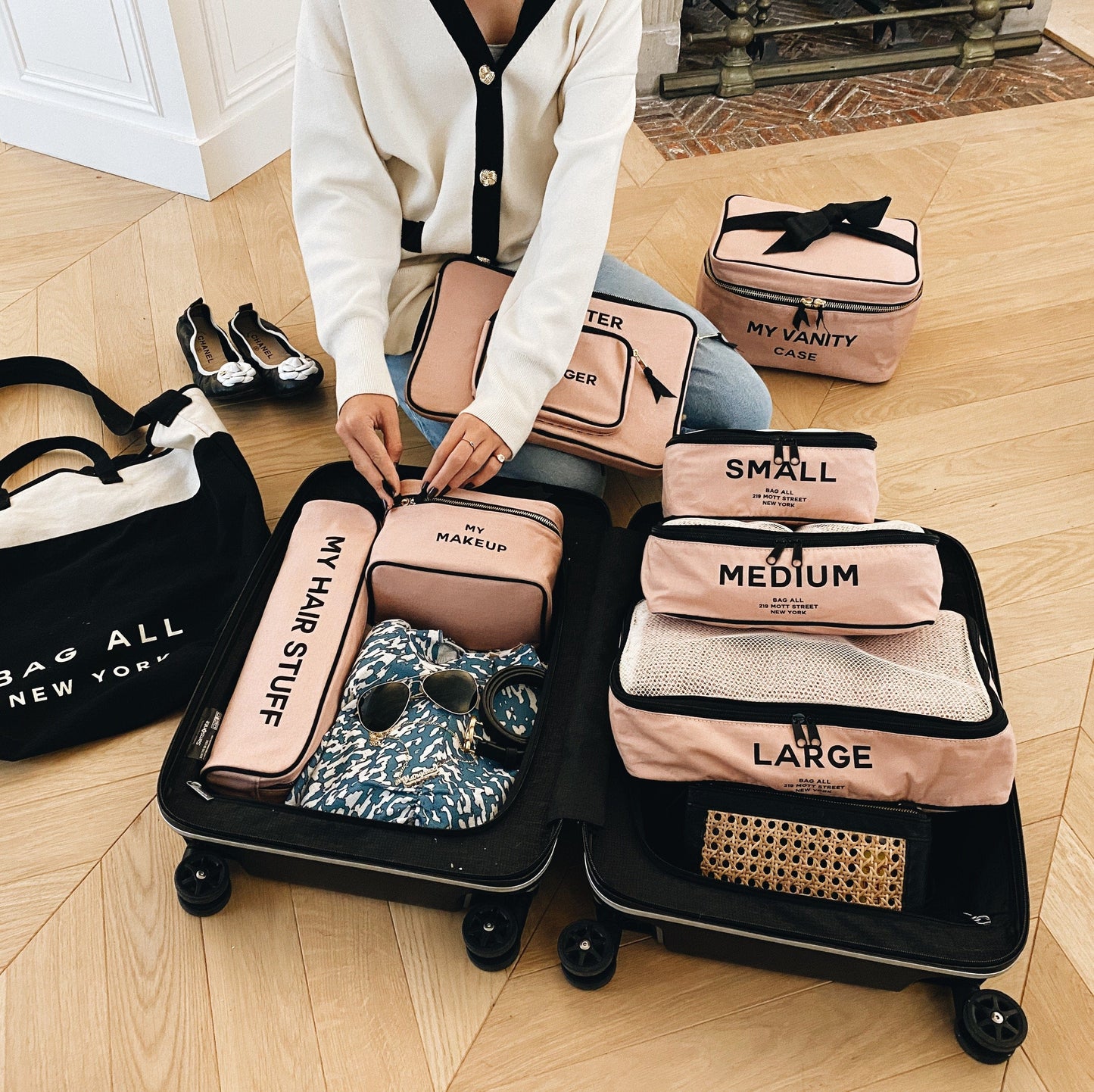 
                                      
                                        A girl packing a suitcase with all pink products from bag-all. 
                                      
                                    