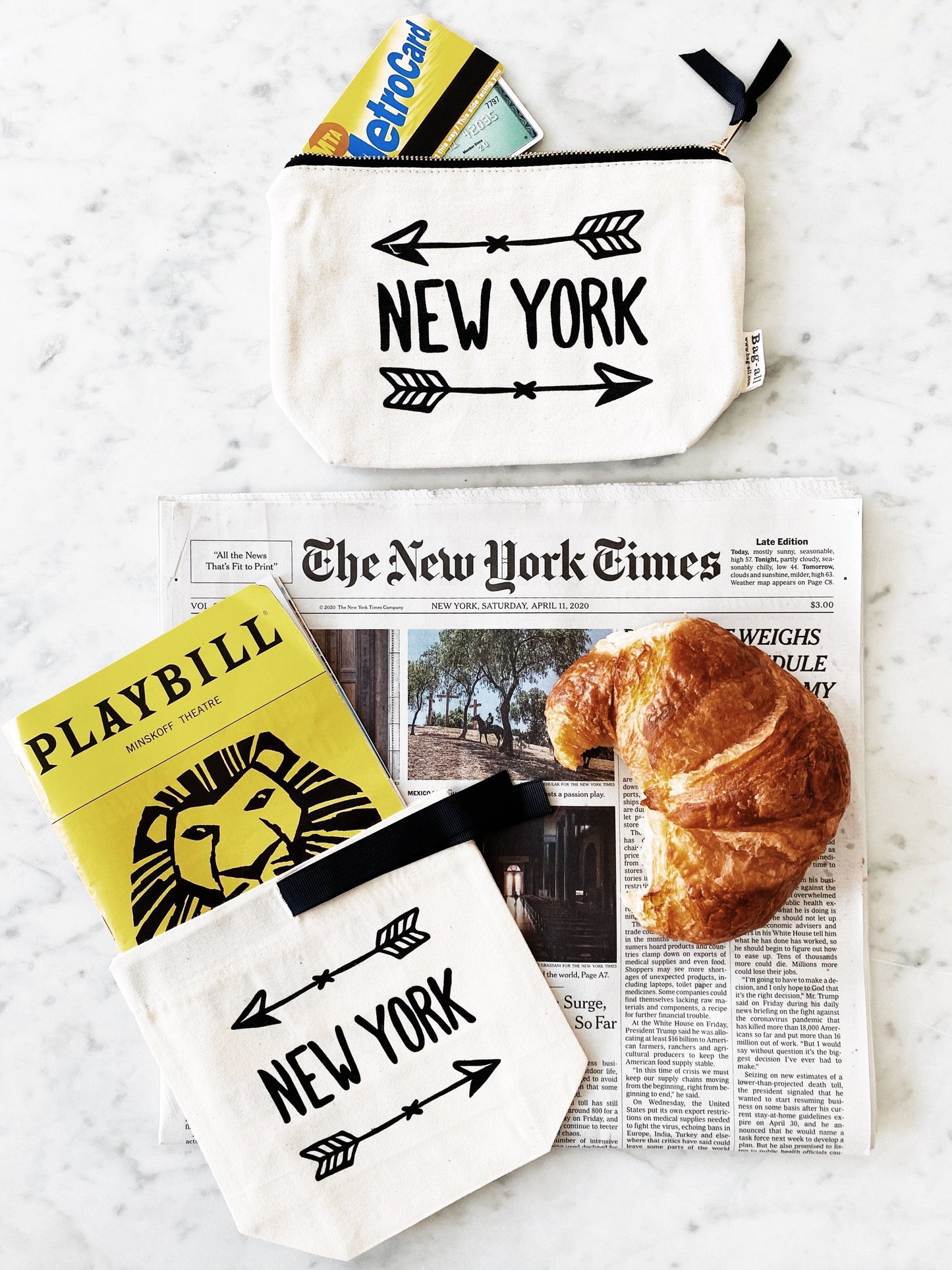 
                                      
                                        New York arrow case next to the new york times and a croissant. 
                                      
                                    