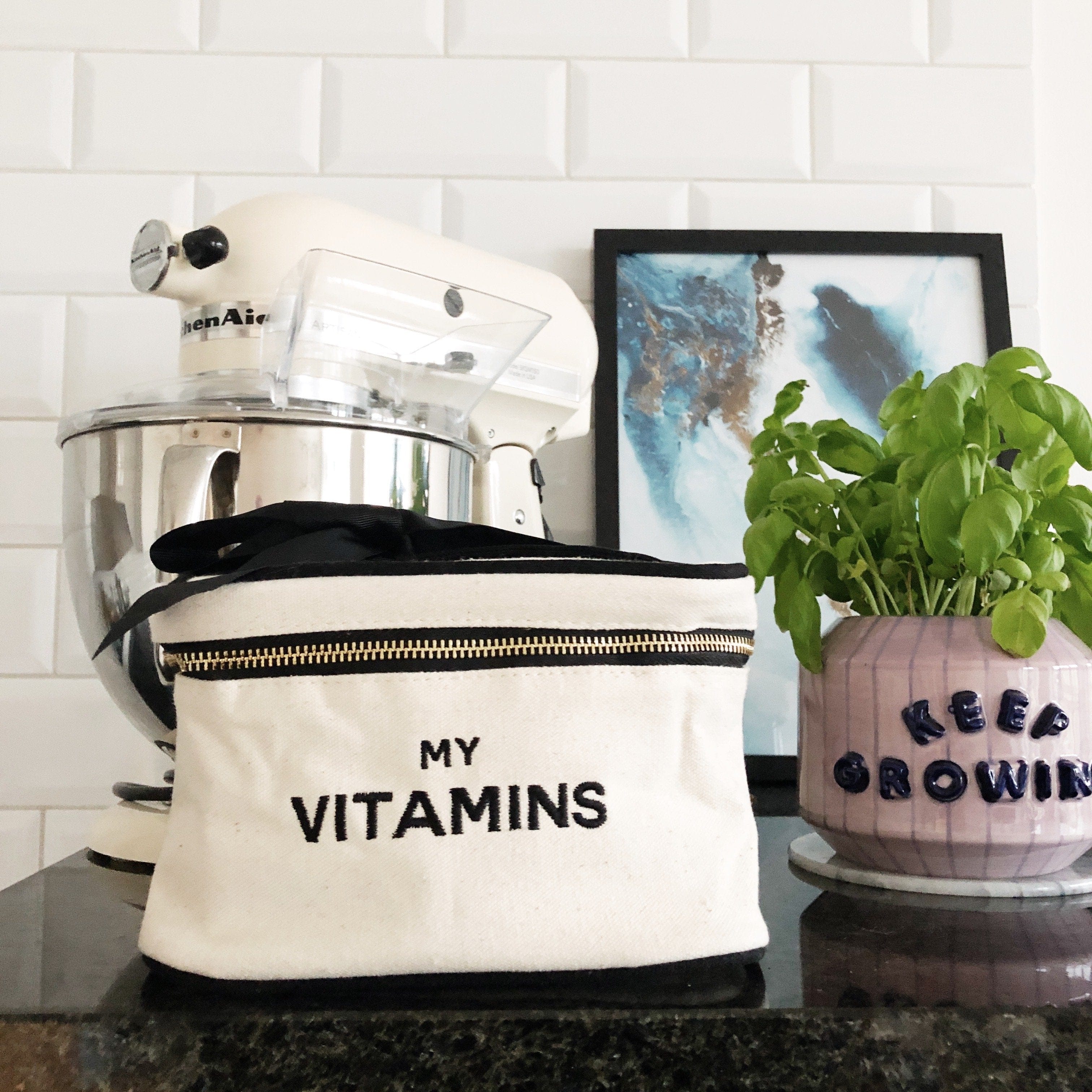 White vitamins box in the kitchen next to a plant. 