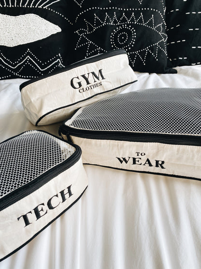 Bag-all organizing bags featuring gym clothes, tech, and wear to wear labels with mesh top panels and black trim, perfect for travel and home organization
